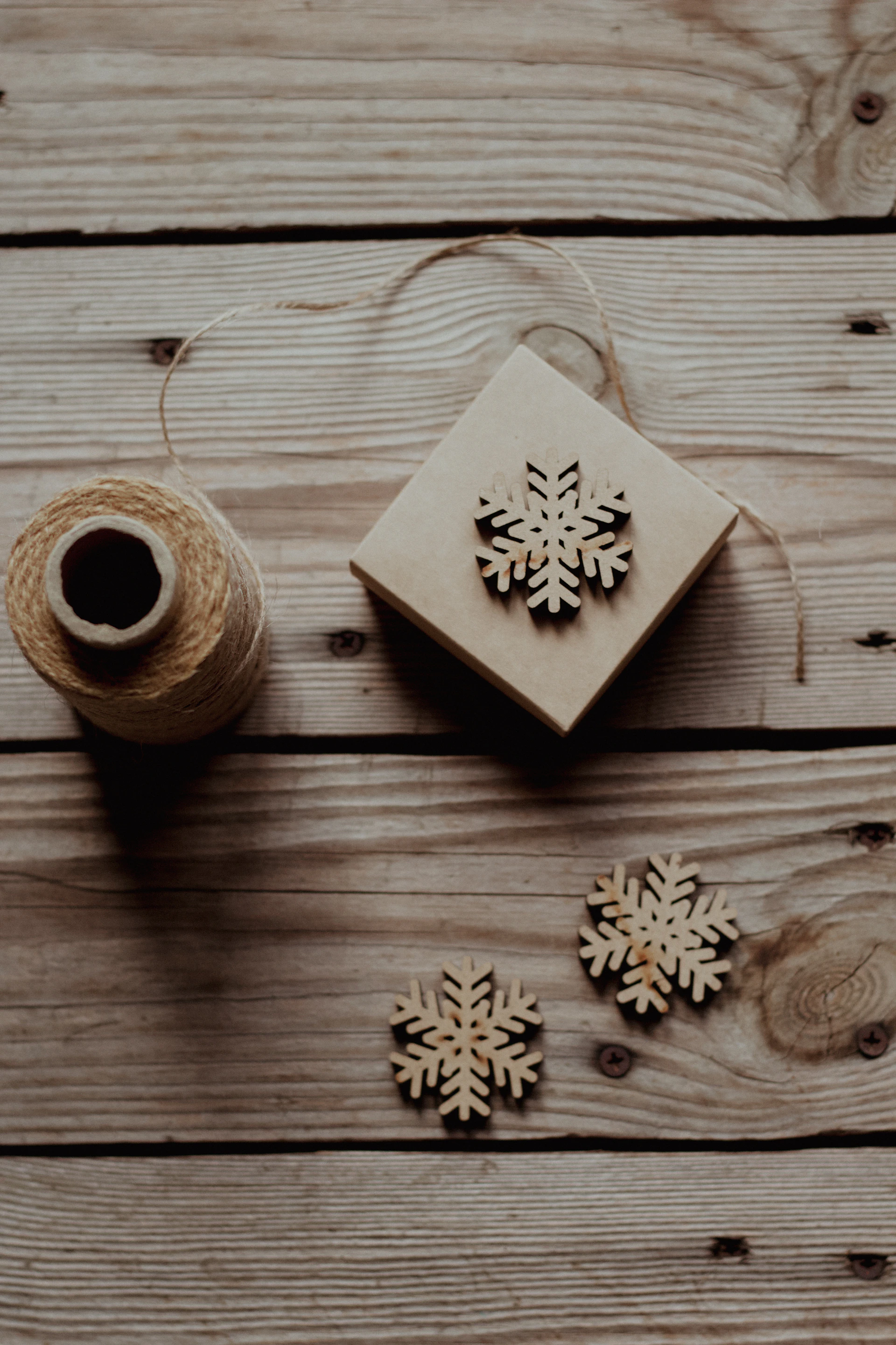 Wooden snowflakes and twine on rustic wood