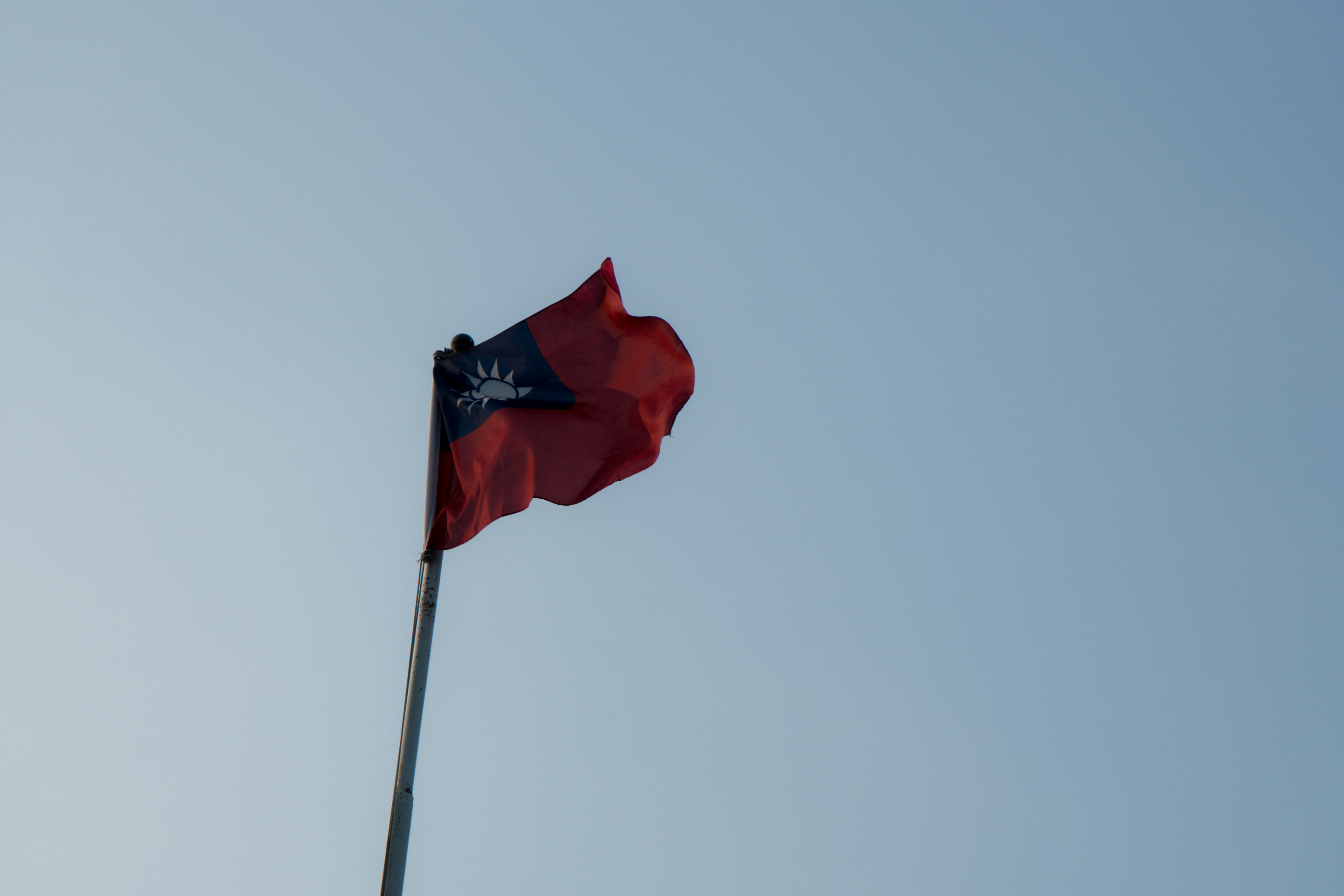 A red flag with a dark emblem waves.