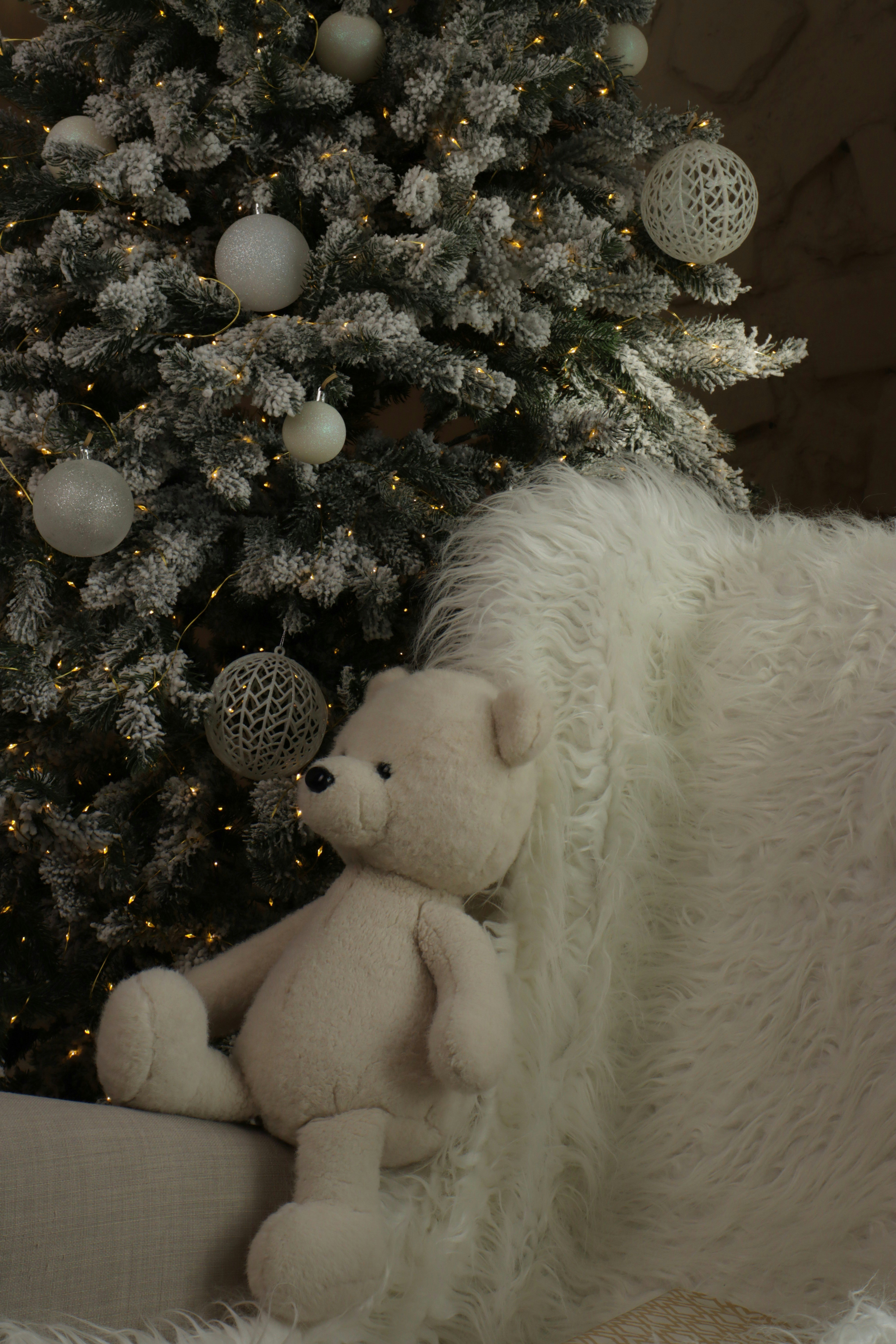 Teddy bear near a decorated christmas tree