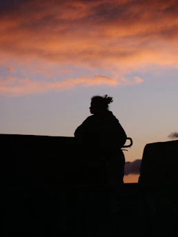 Silhouette of a person against a colorful sunset sky