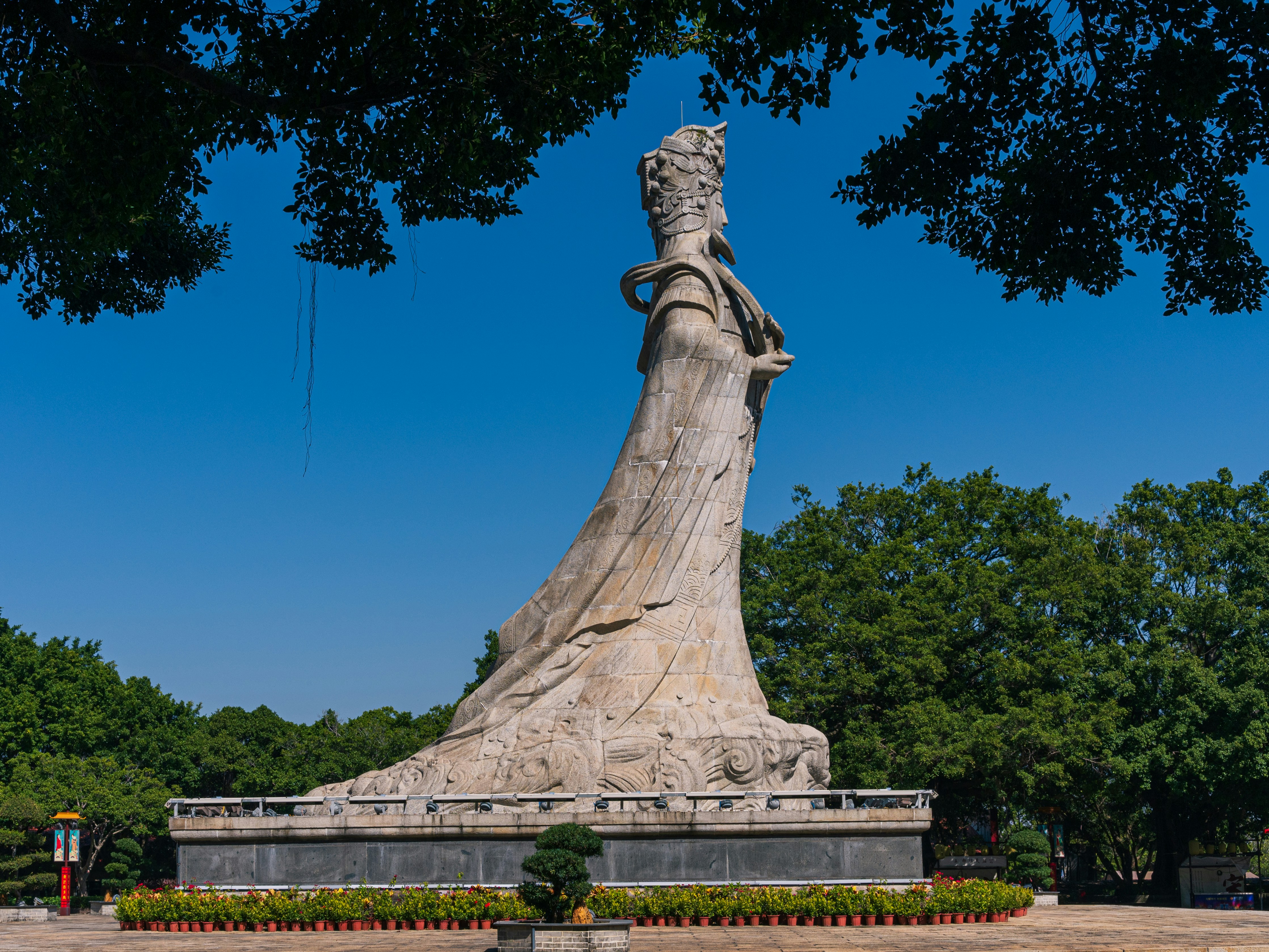 Large stone statue of a woman against blue sky