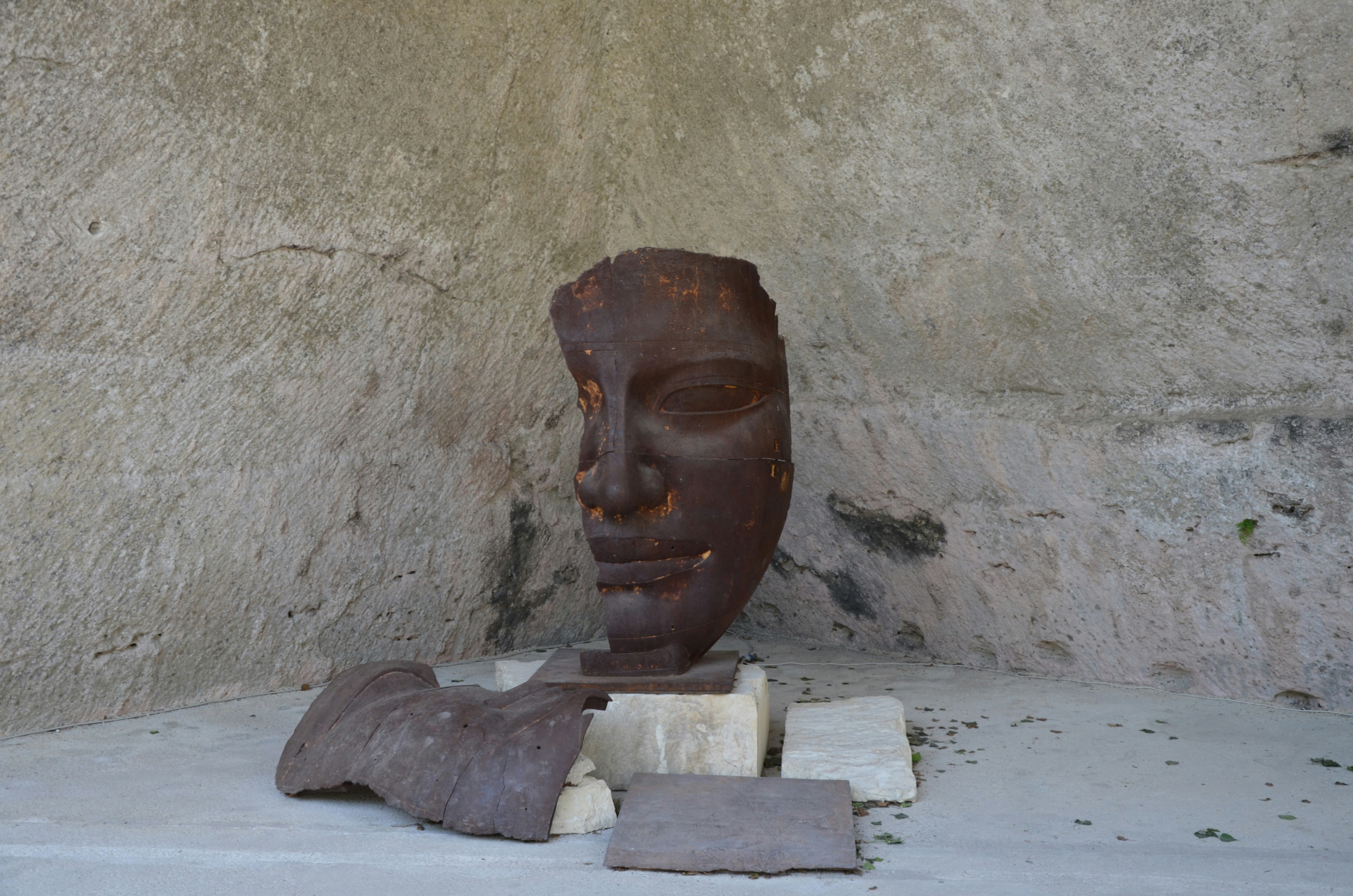 A weathered stone sculpture of a human face
