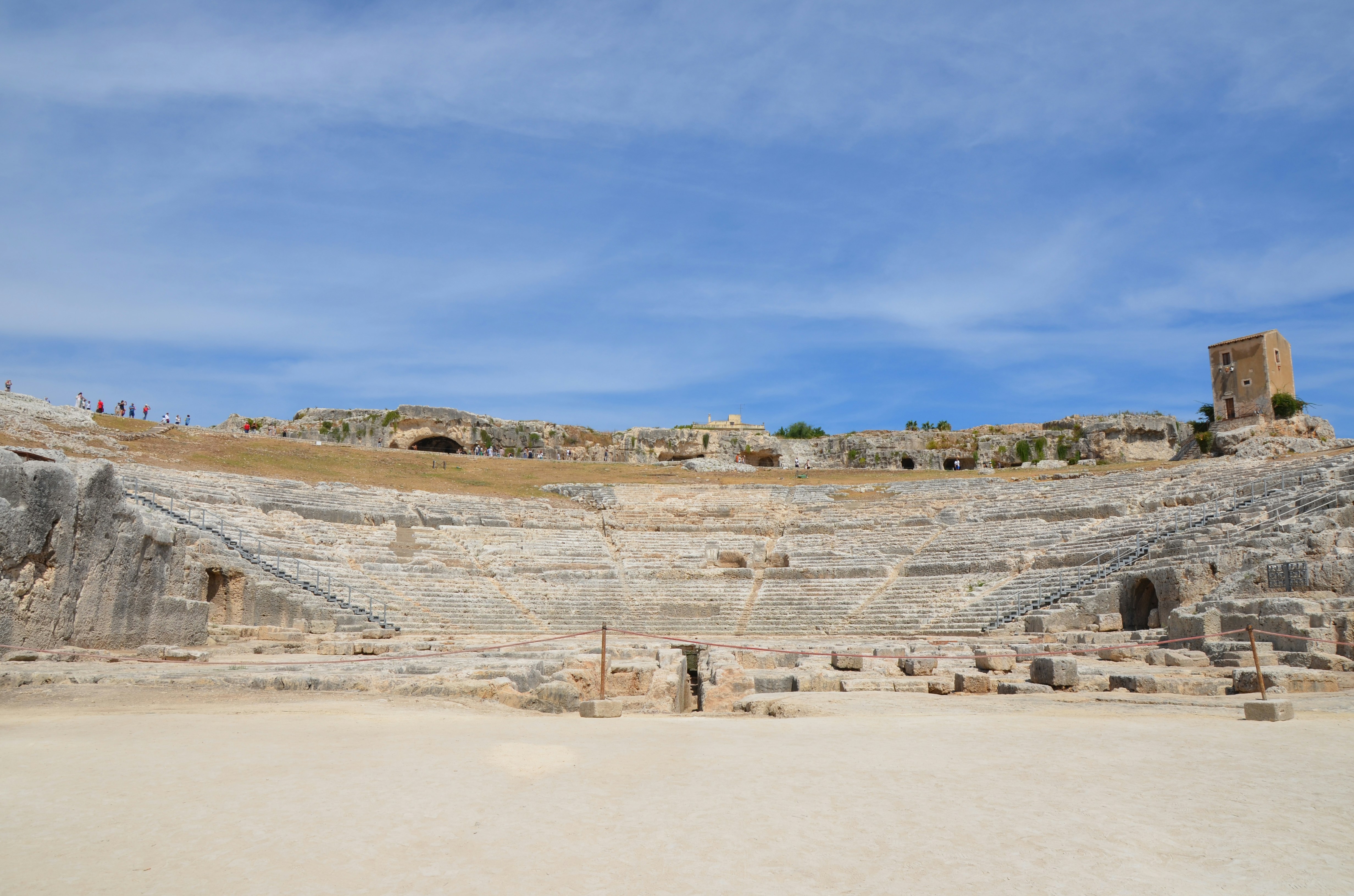 Anfiteatro romano antiguo bajo un cielo azul despejado.