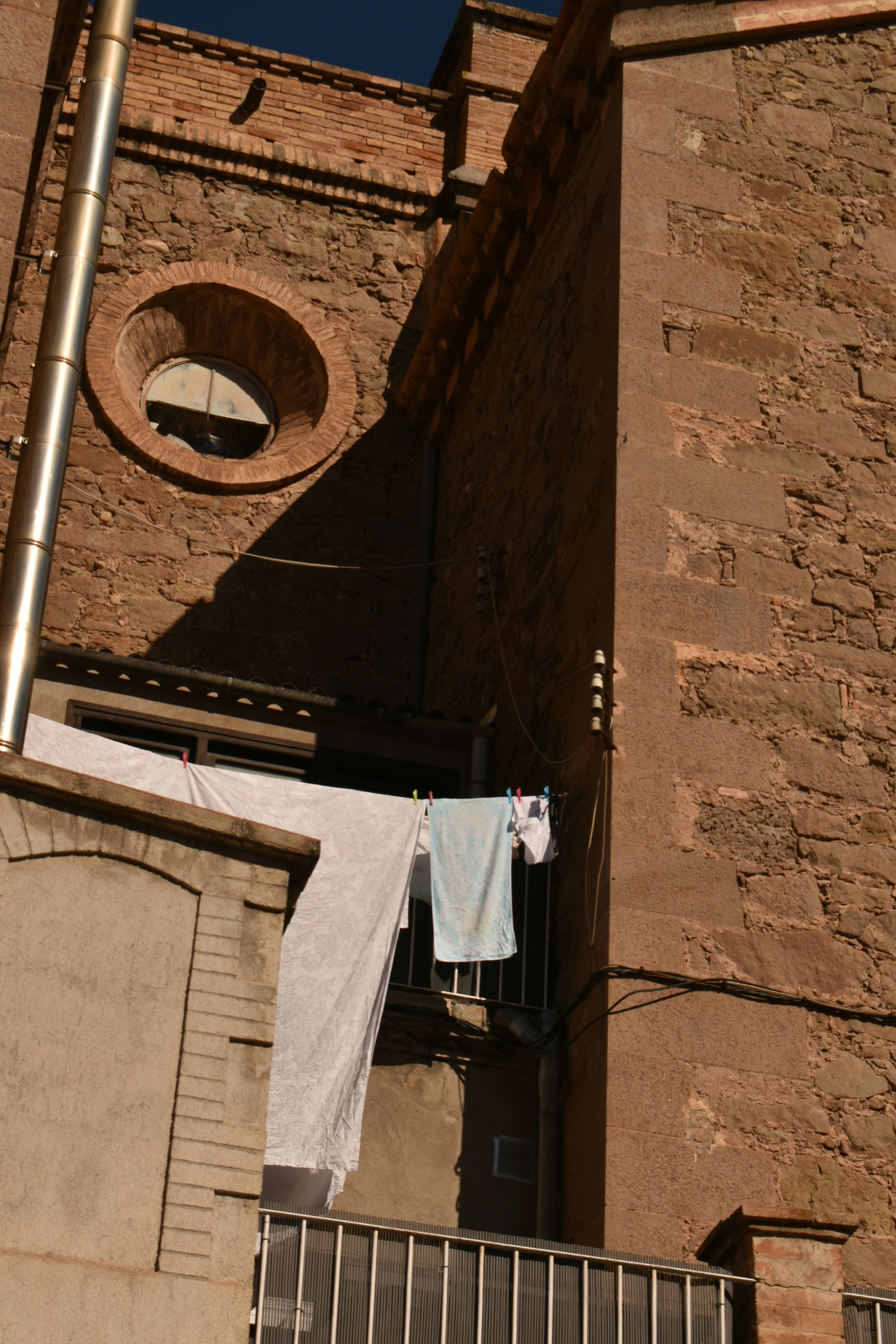 Il bucato che asciuga su un balcone contro un edificio di mattoni.
