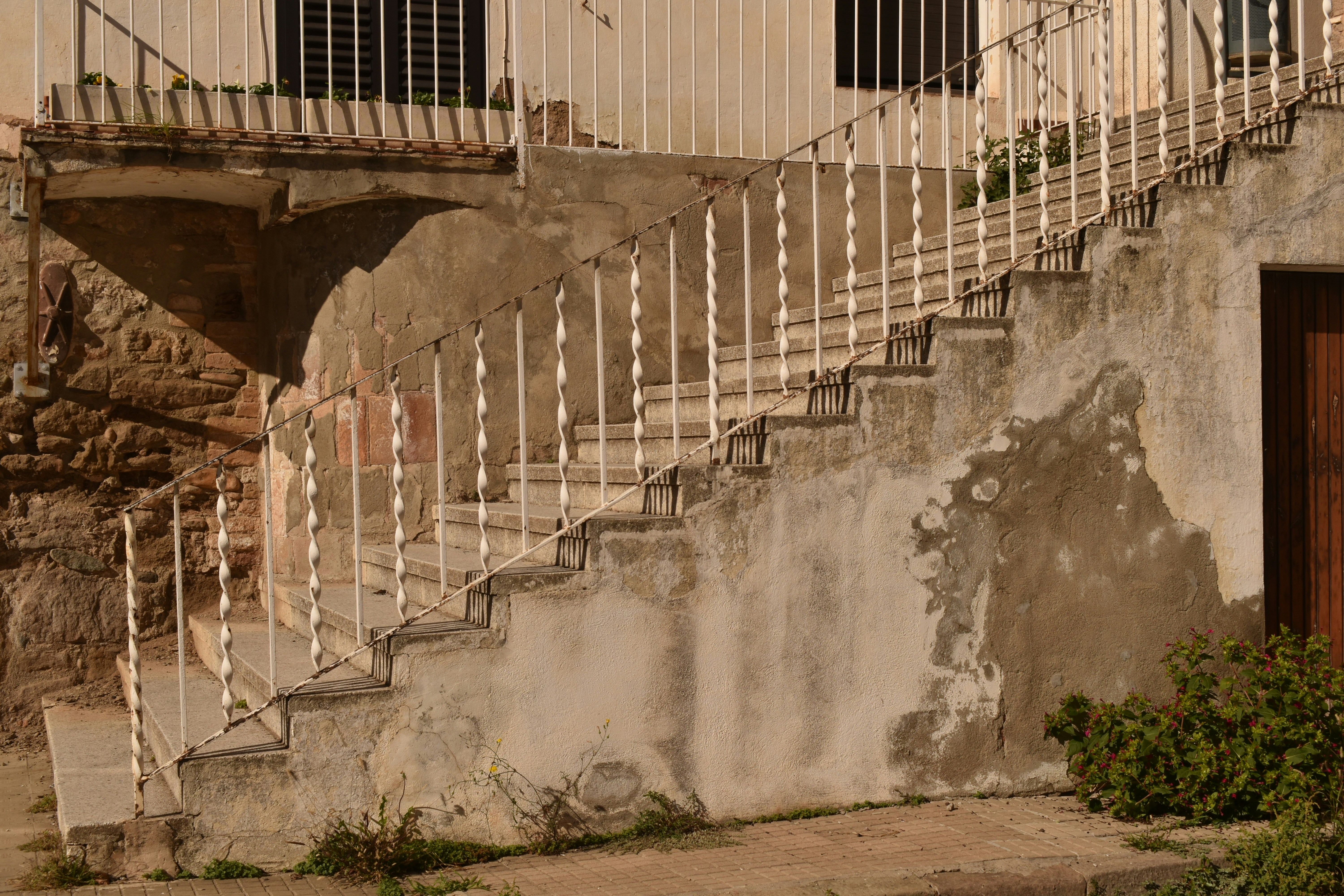 An old weathered outdoor staircase with white railings.