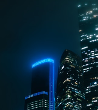Modern skyscrapers illuminated at night with blue accents.
