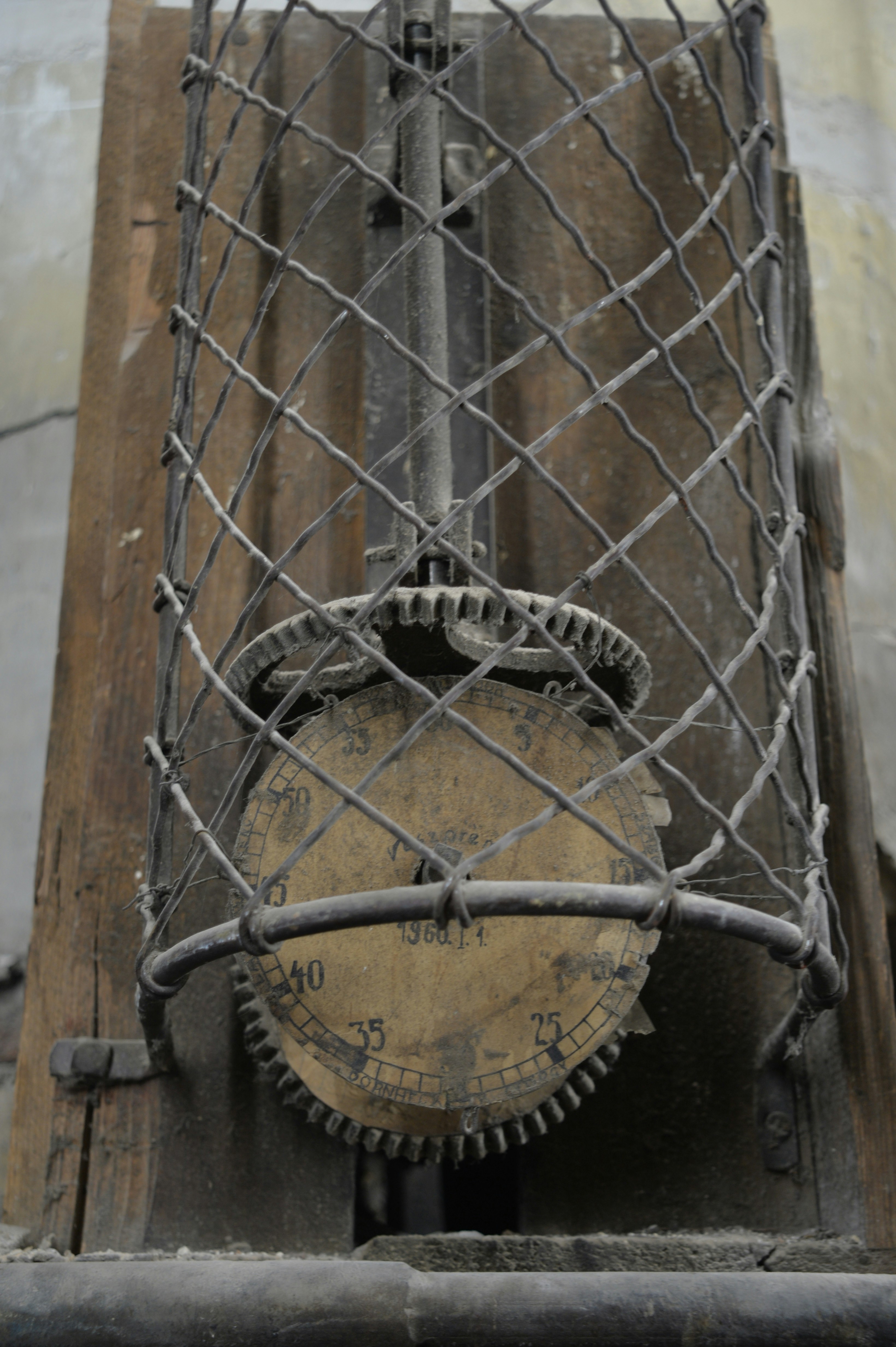 Close-up of an old clock mechanism with gears and dial.