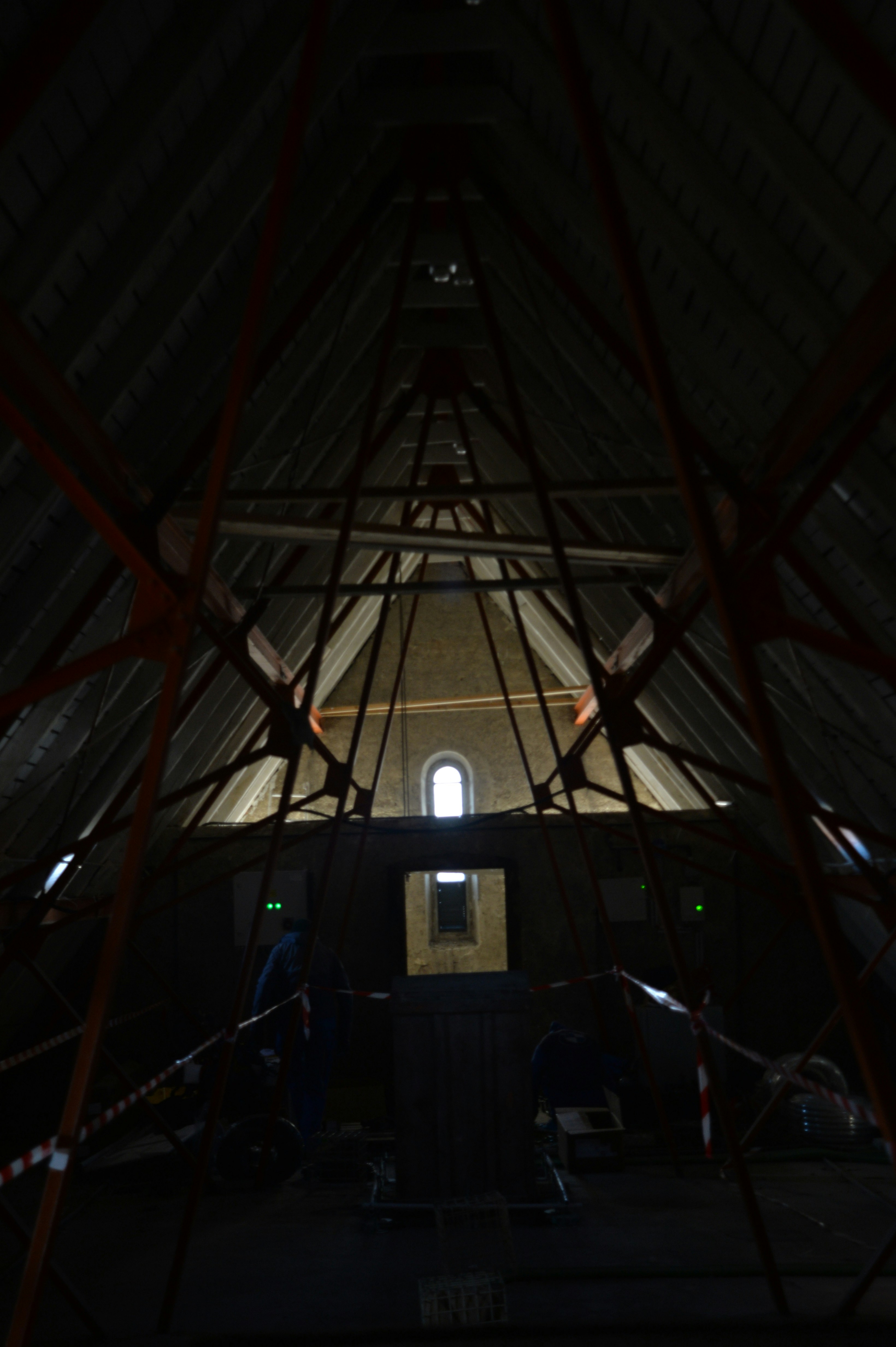 Interior view of a dark attic with wooden beams.