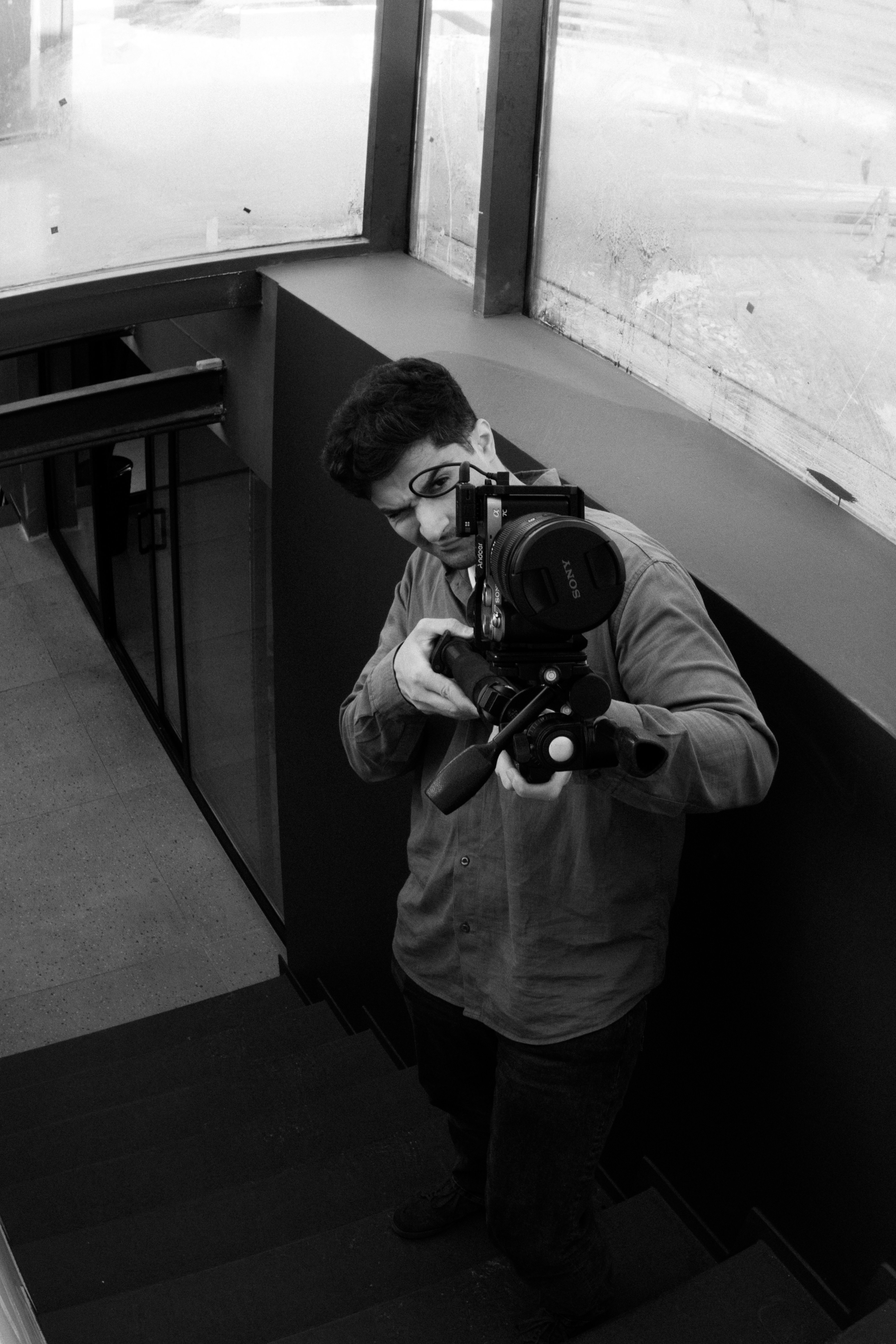 Man filming with professional camera on stairs