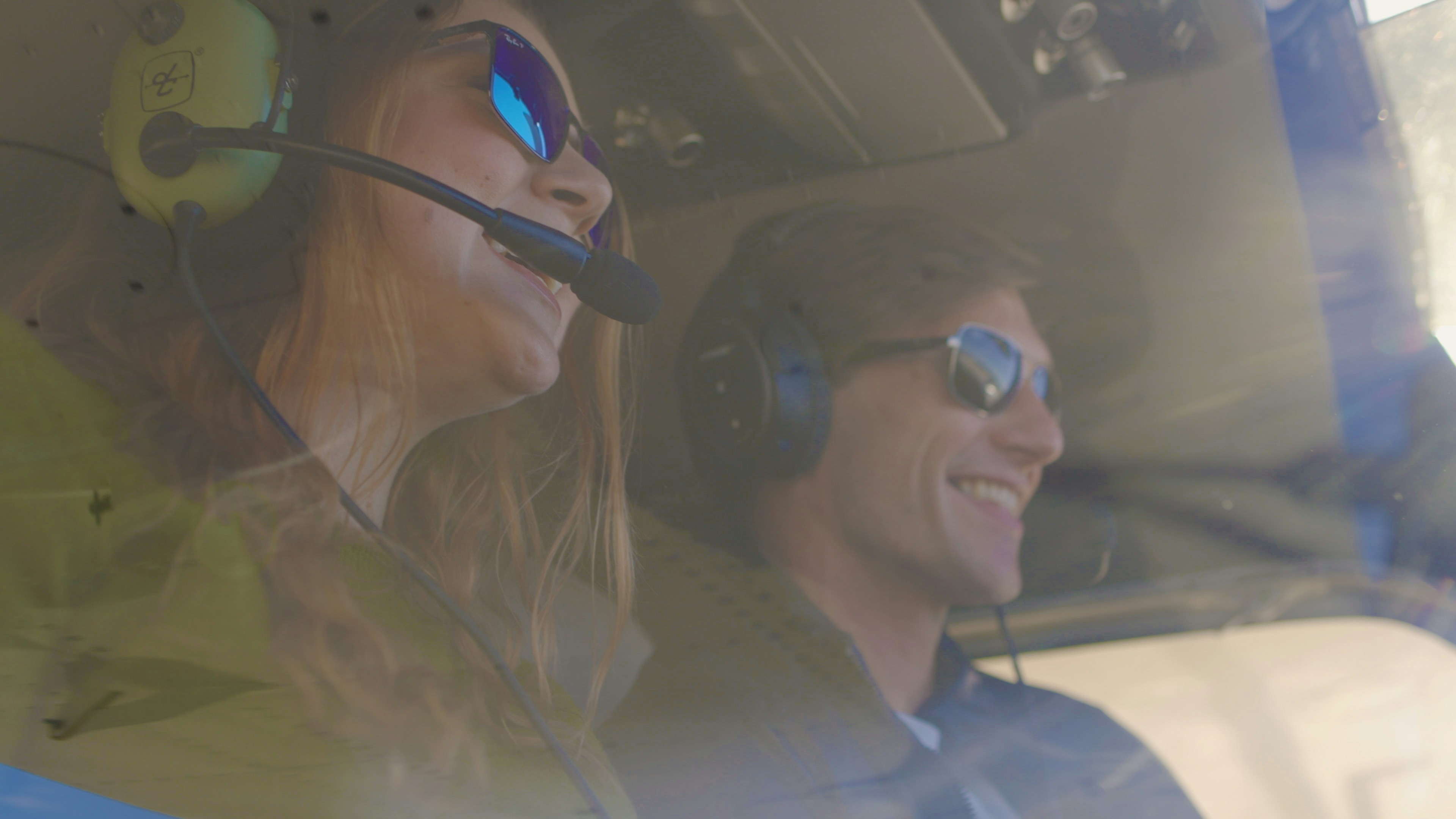 Due persone in elicottero con occhiali da sole e cuffie