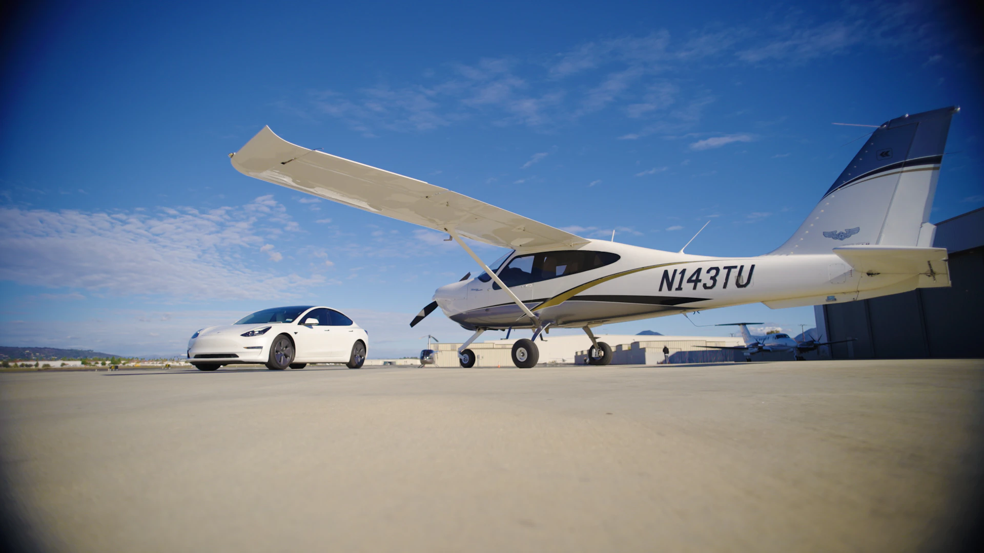 White airplane and car parked on tarmac