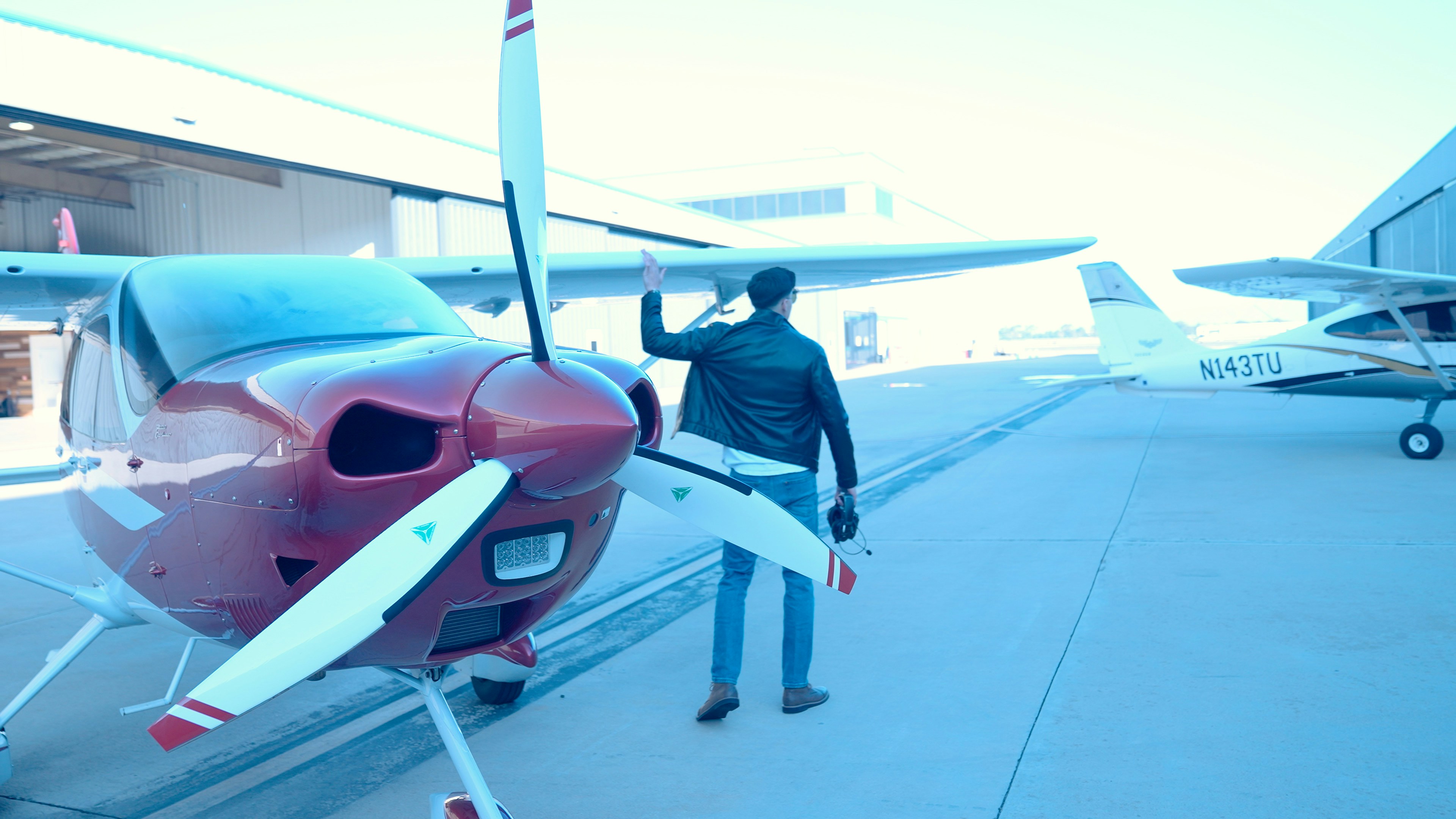 Man standing by a small airplane on tarmac
