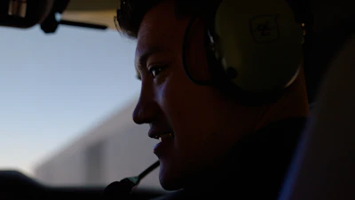 Pilot wearing headset smiles while flying