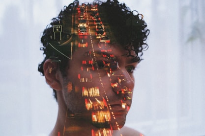 Double exposure of man's face and traffic lights