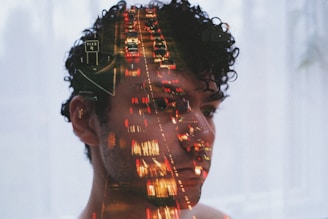 Double exposure of man's face and traffic lights