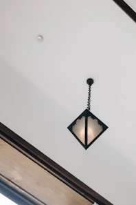 A diamond-shaped pendant light hangs from ceiling.