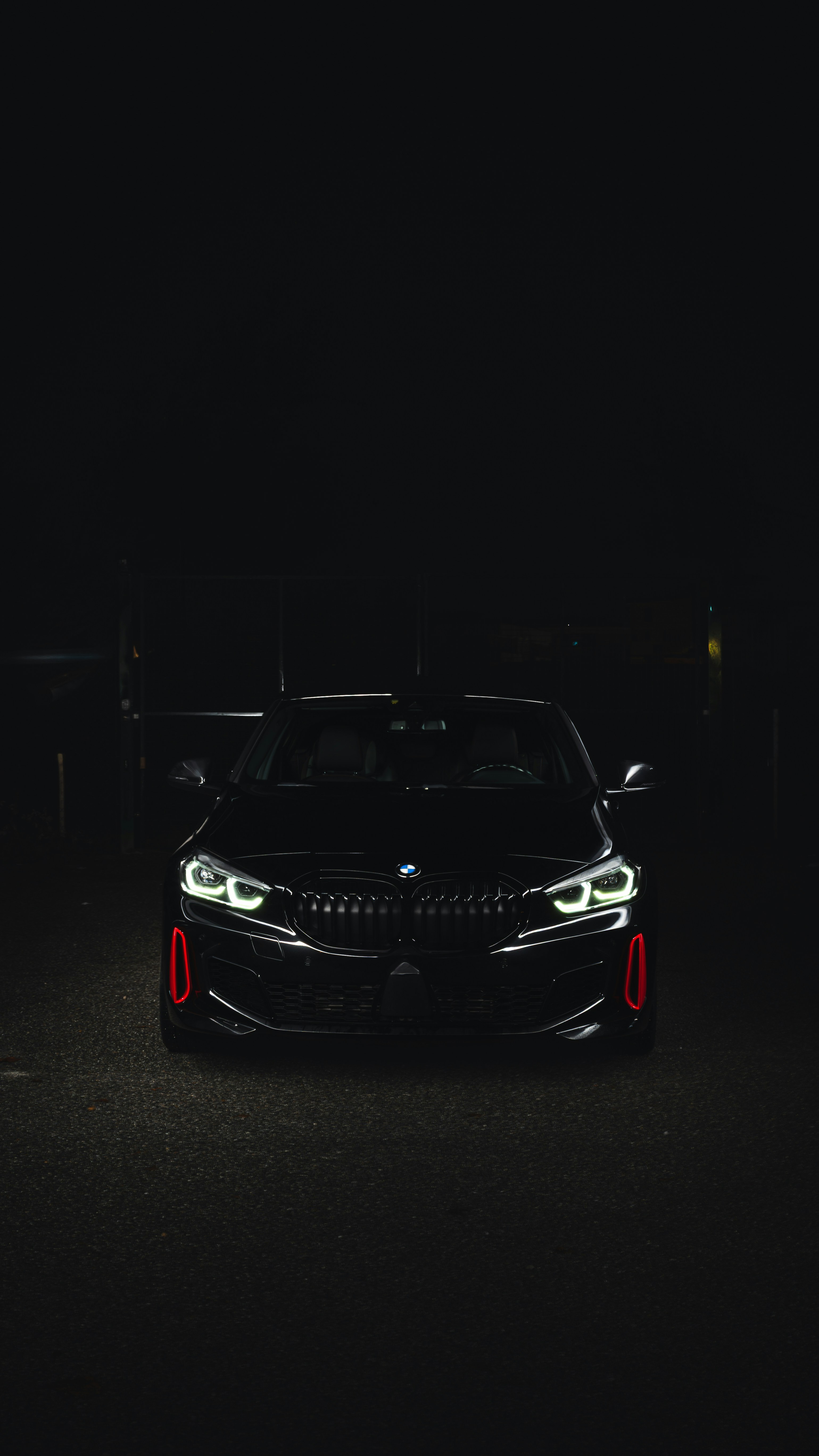 Black BMW car with headlights on at night