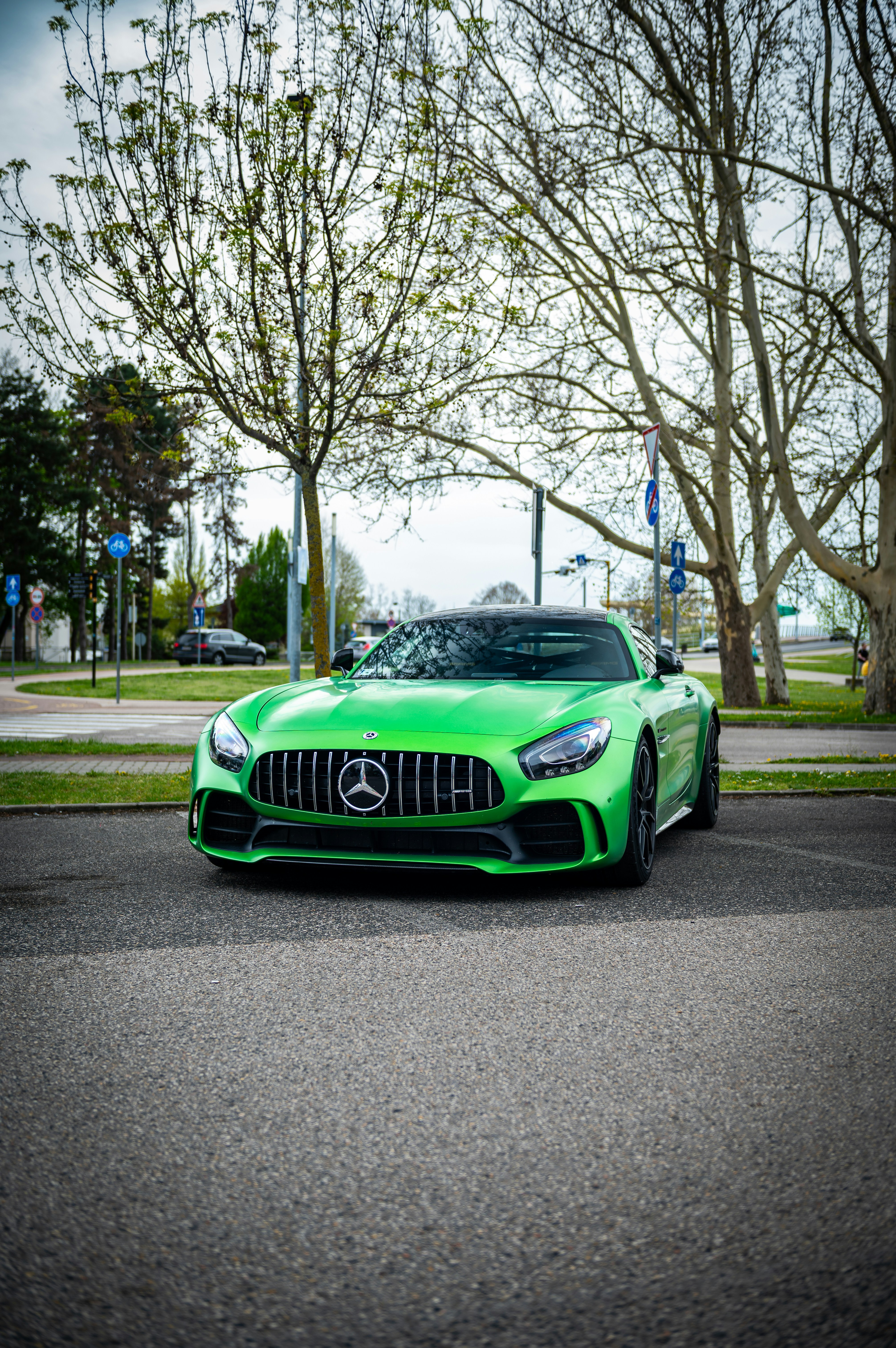 A bright green sports car parked on asphalt.