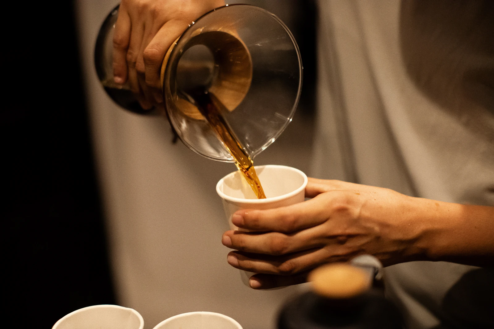 Pouring coffee from a pour-over brewer into a cup