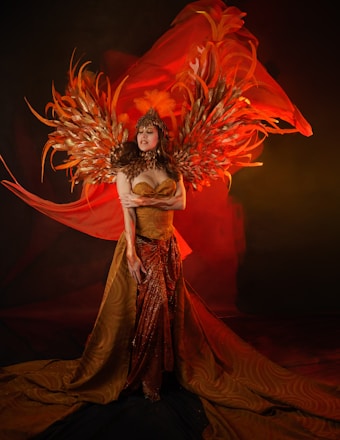 Woman in elaborate costume with golden wings and flowing fabric