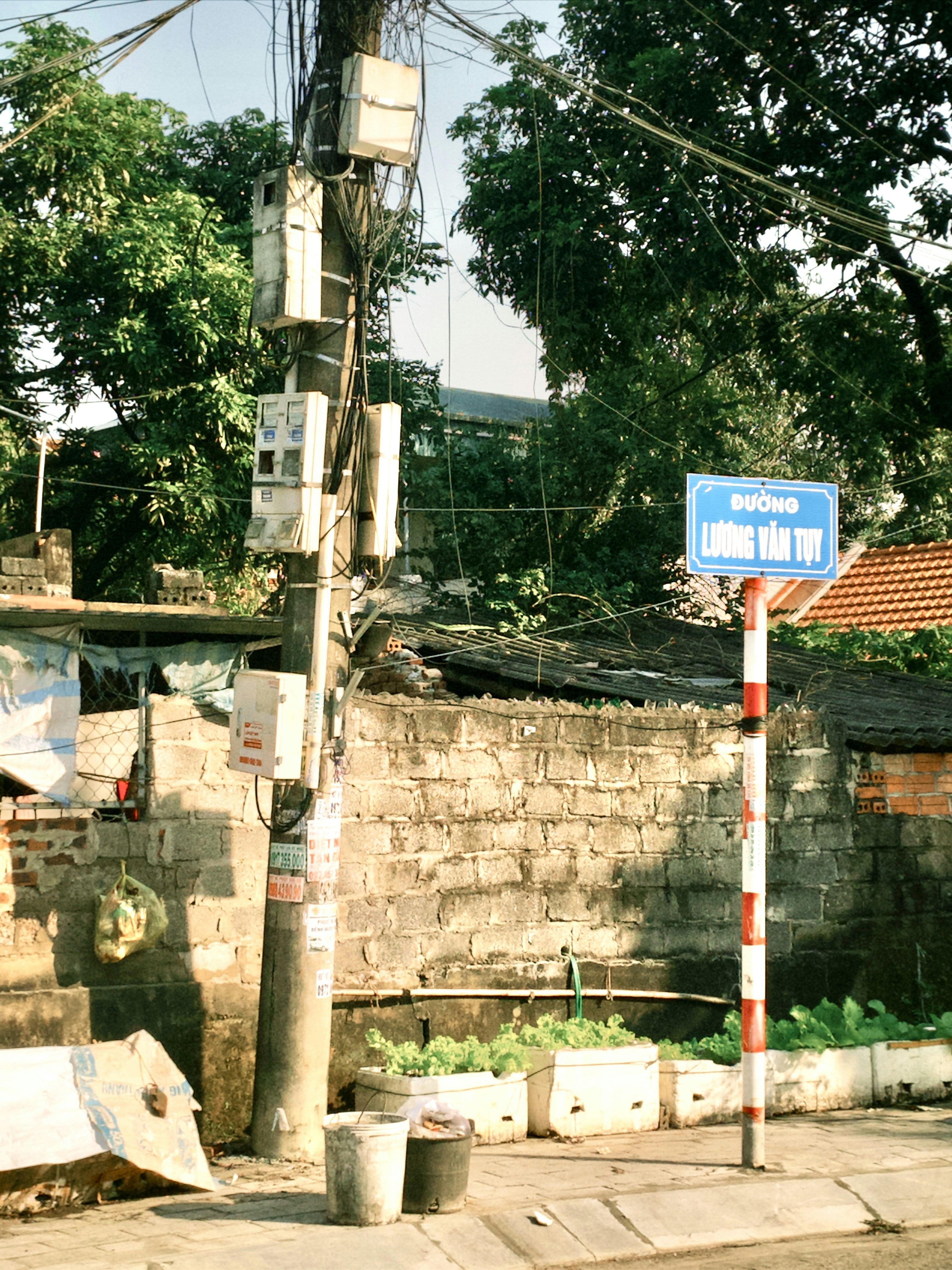 Placa de rua e poste de utilidade com áreas verdes
