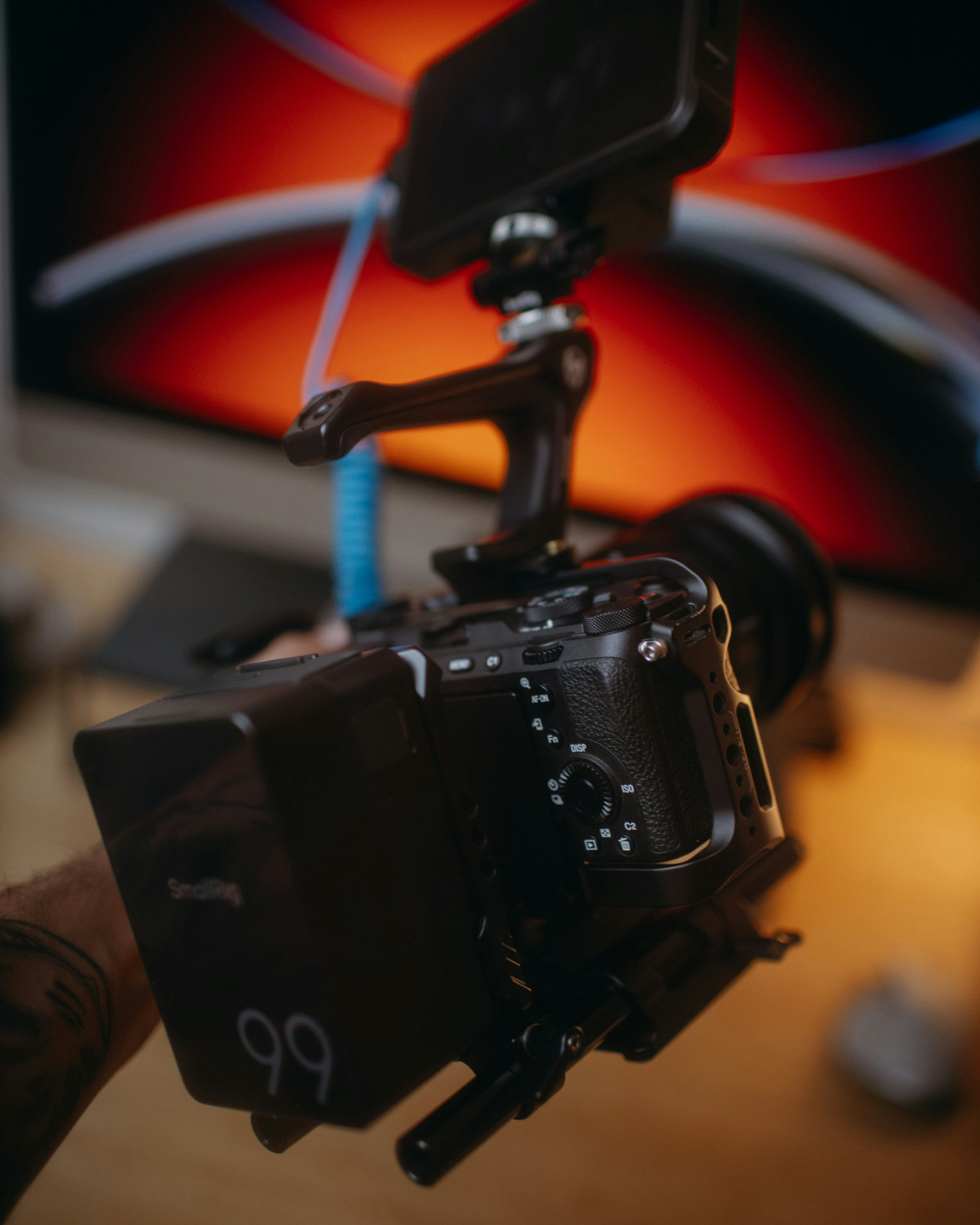 Camera rig with phone attached, monitor in background.