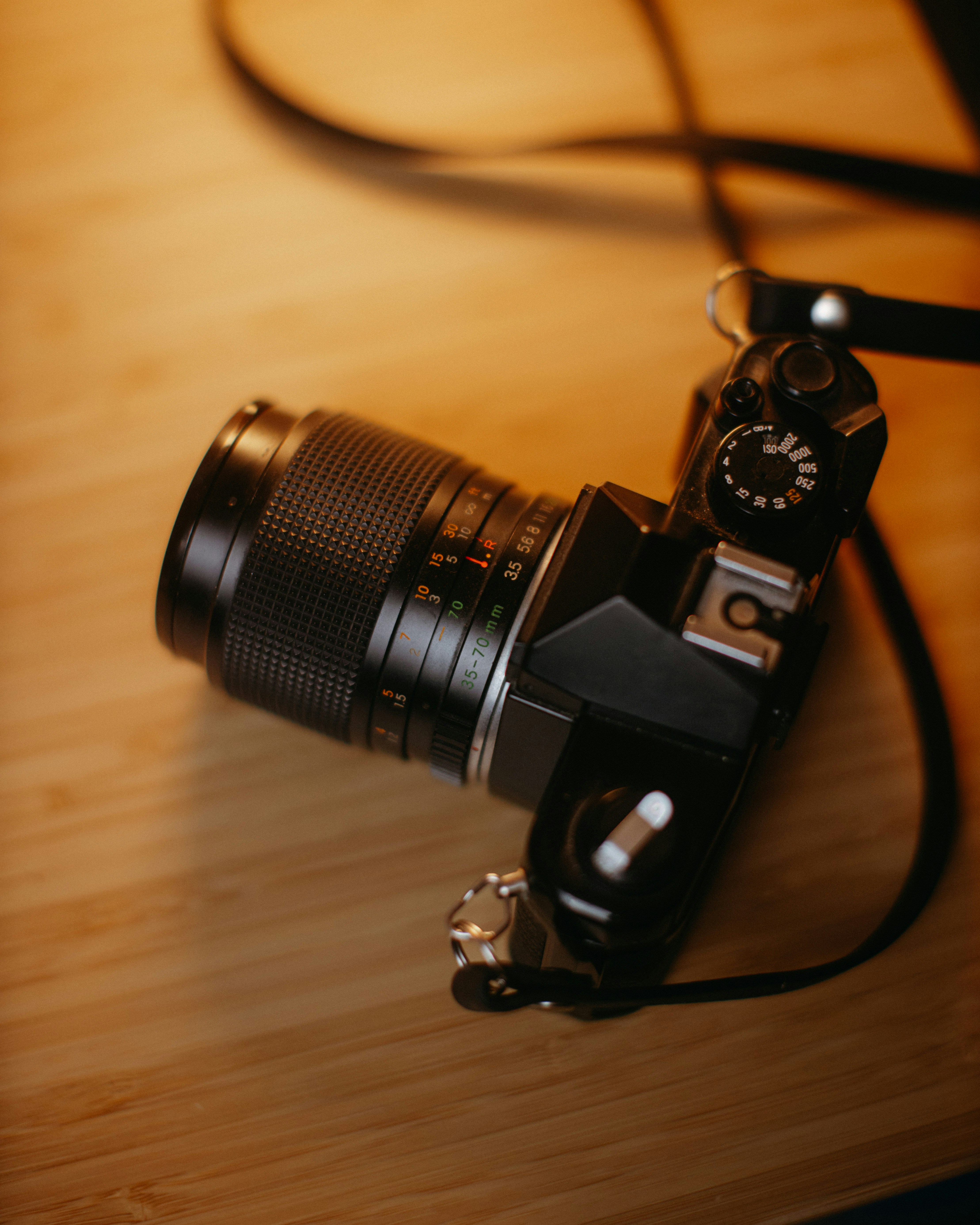 A vintage camera rests on a wooden surface.