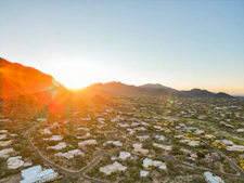 Sunset over a desert neighborhood with mountains.