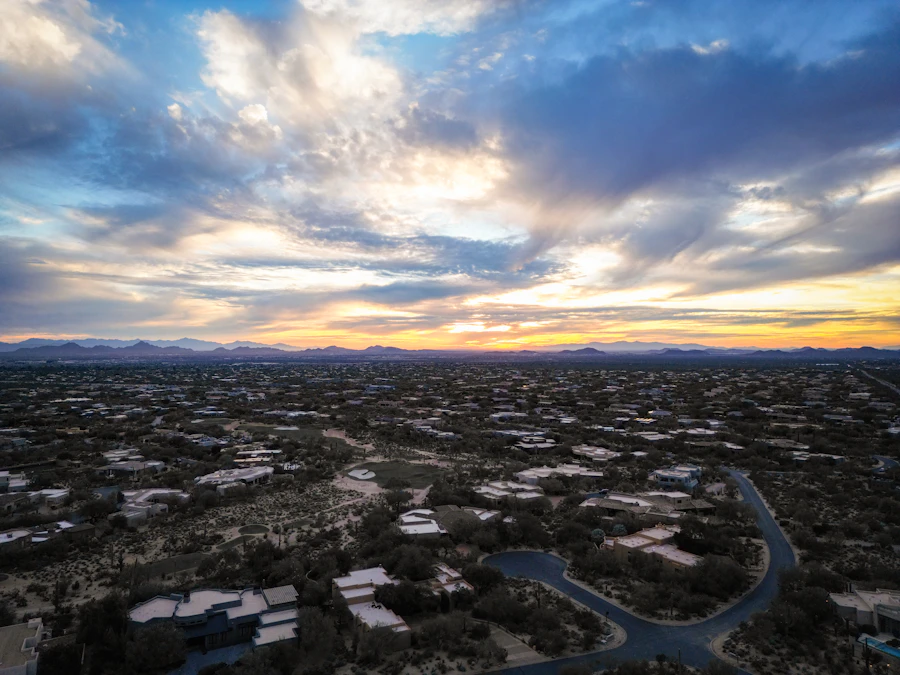 Aerial view of desert neighborhoods at sunset beneath dramatic clouds