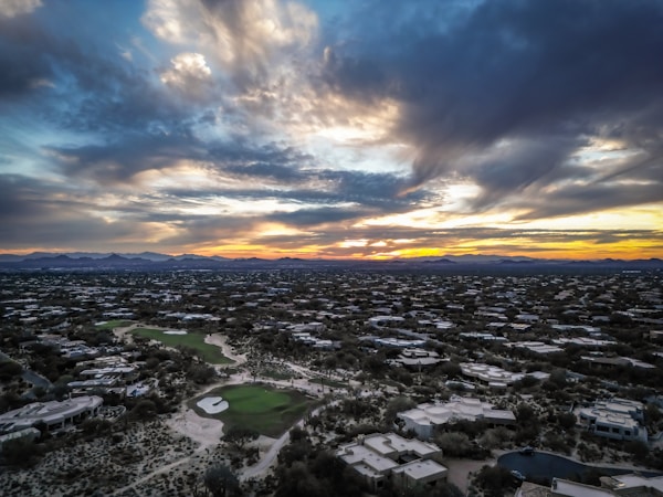 Sunset over a sprawling desert city landscape, the view context surrounding Summerlin on the west edge of the Las Vegas valley