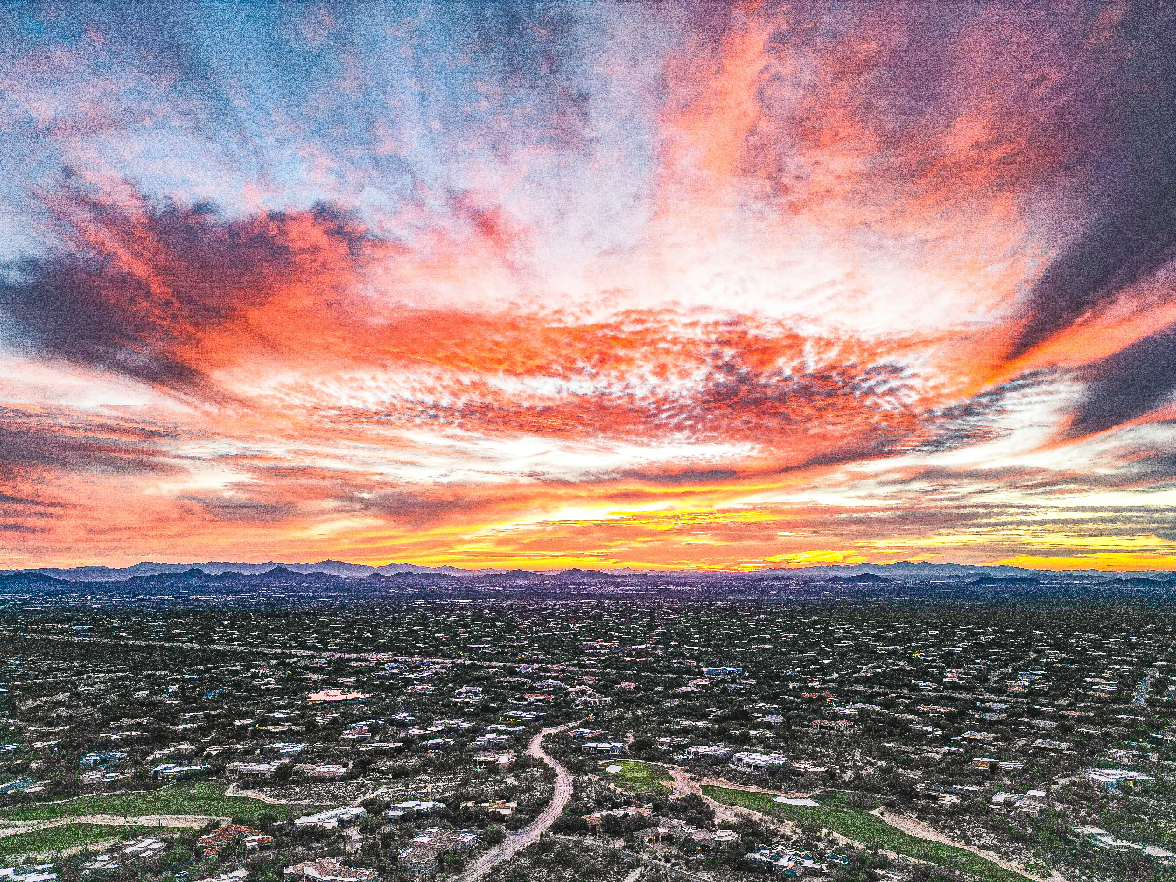 Vibrant sunset over a sprawling suburban landscape.