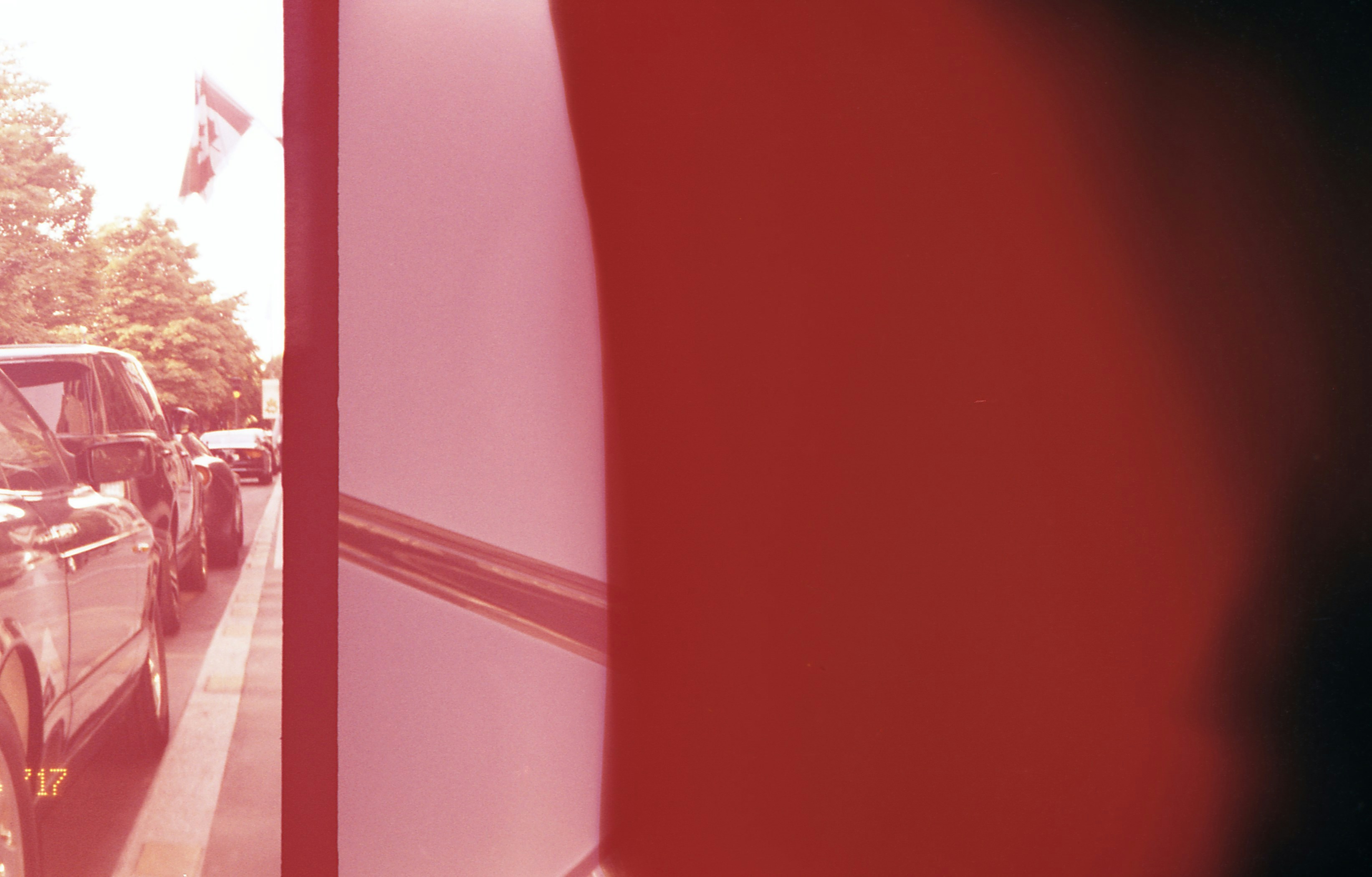 Cars lined up on a street with a flag.