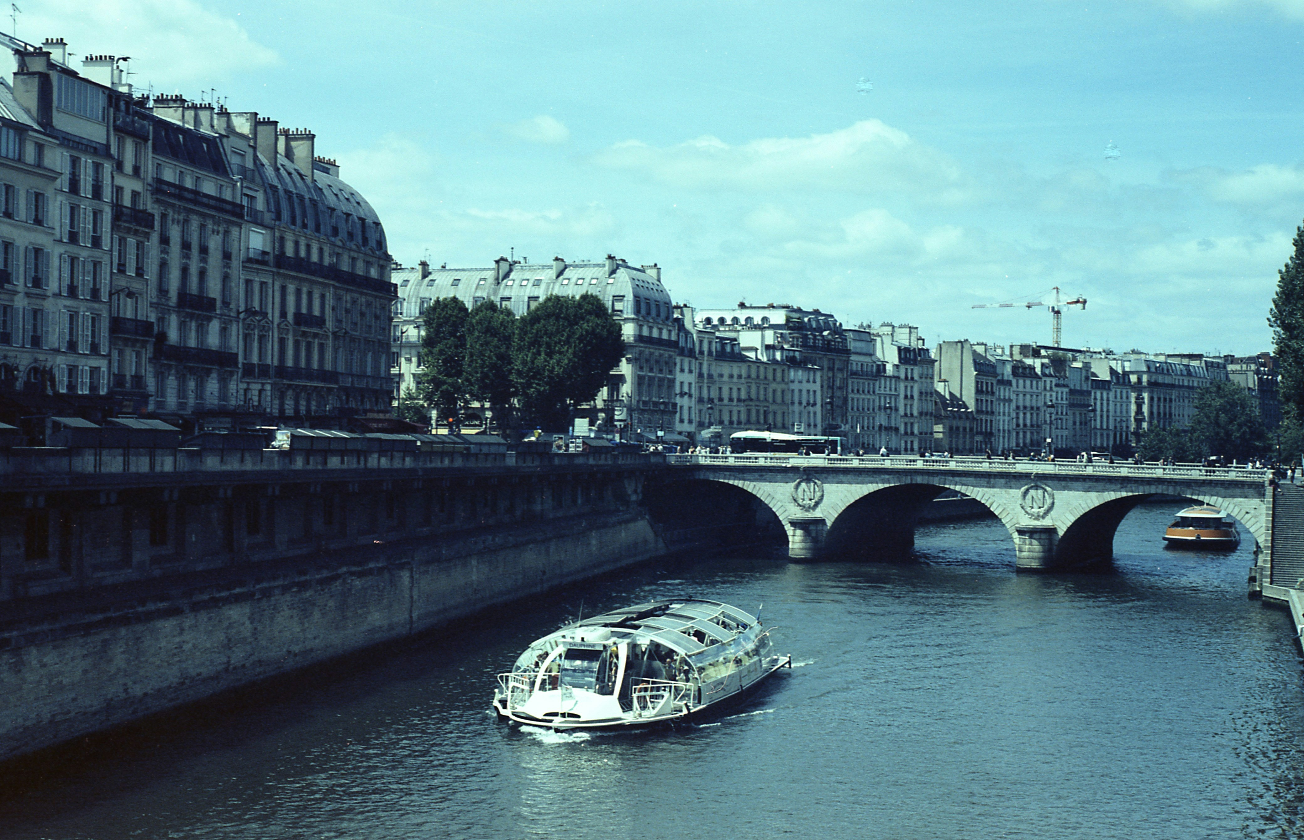 Boat on seine river with parisian buildings and bridge