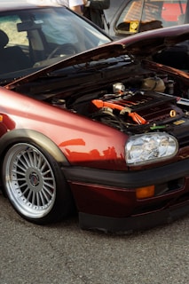 Maroon car with hood open showing engine