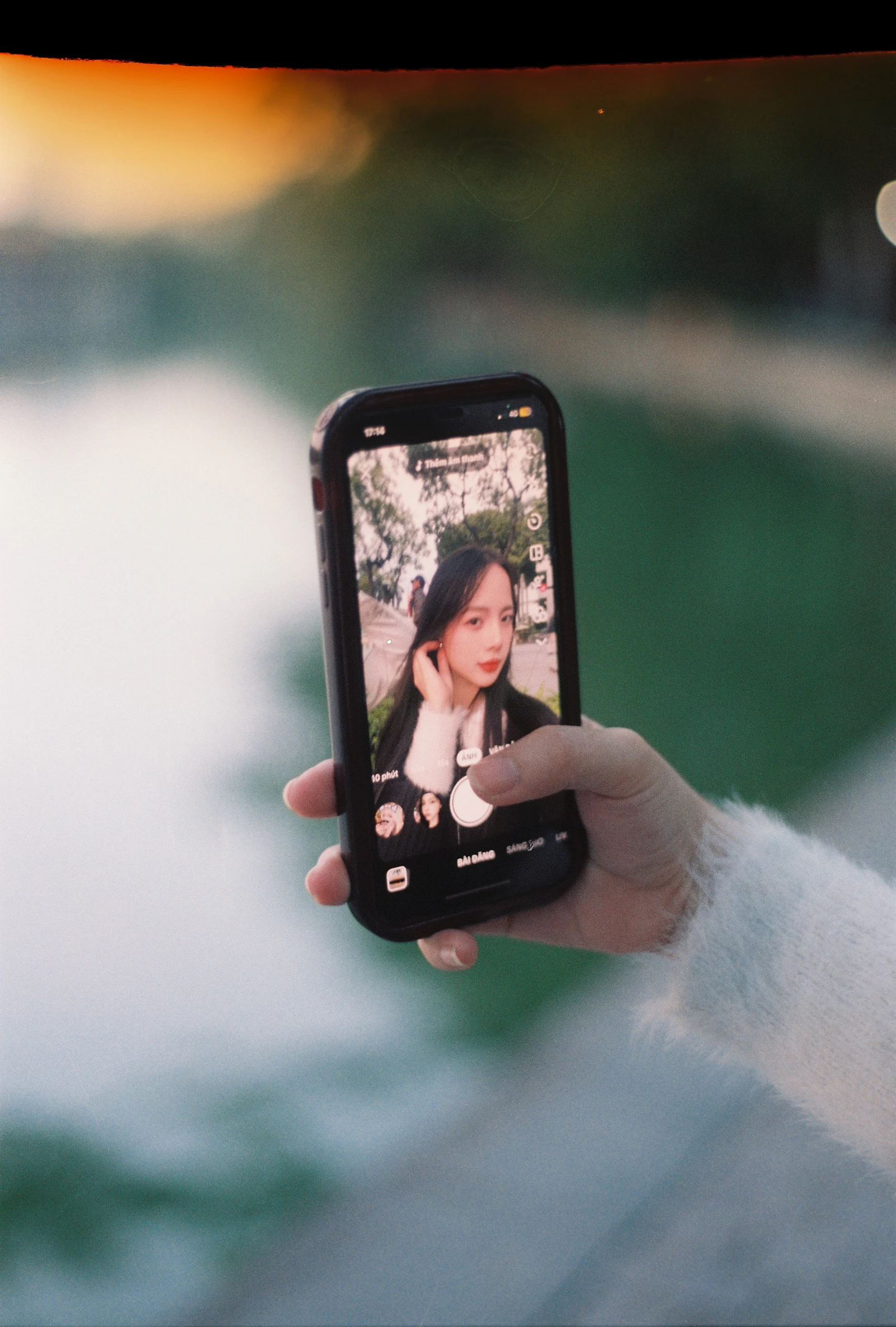 Traveller using a smartphone outdoors near Hoan Kiem Lake in Hanoi, Vietnam