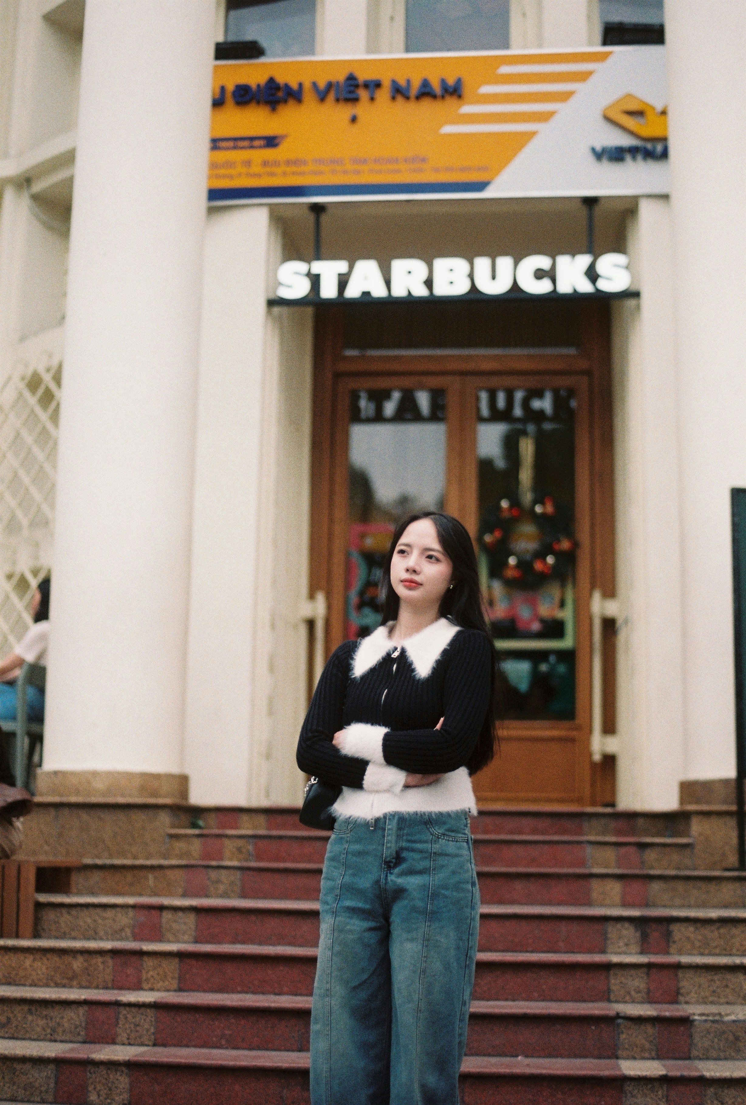 Junge Frau, die vor Starbucks steht