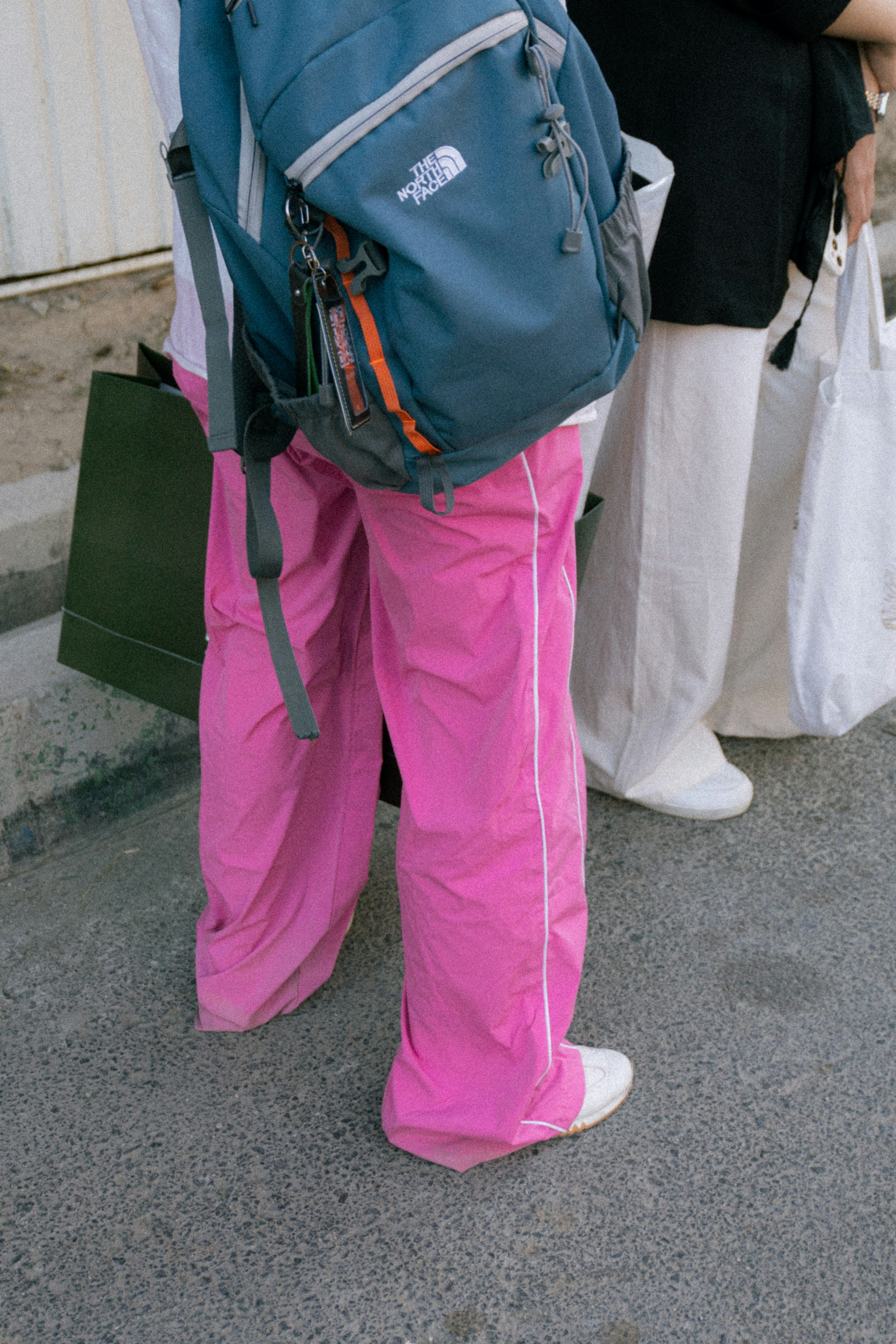 Person in knallpinken Hosen mit Rucksack und Rucksack.