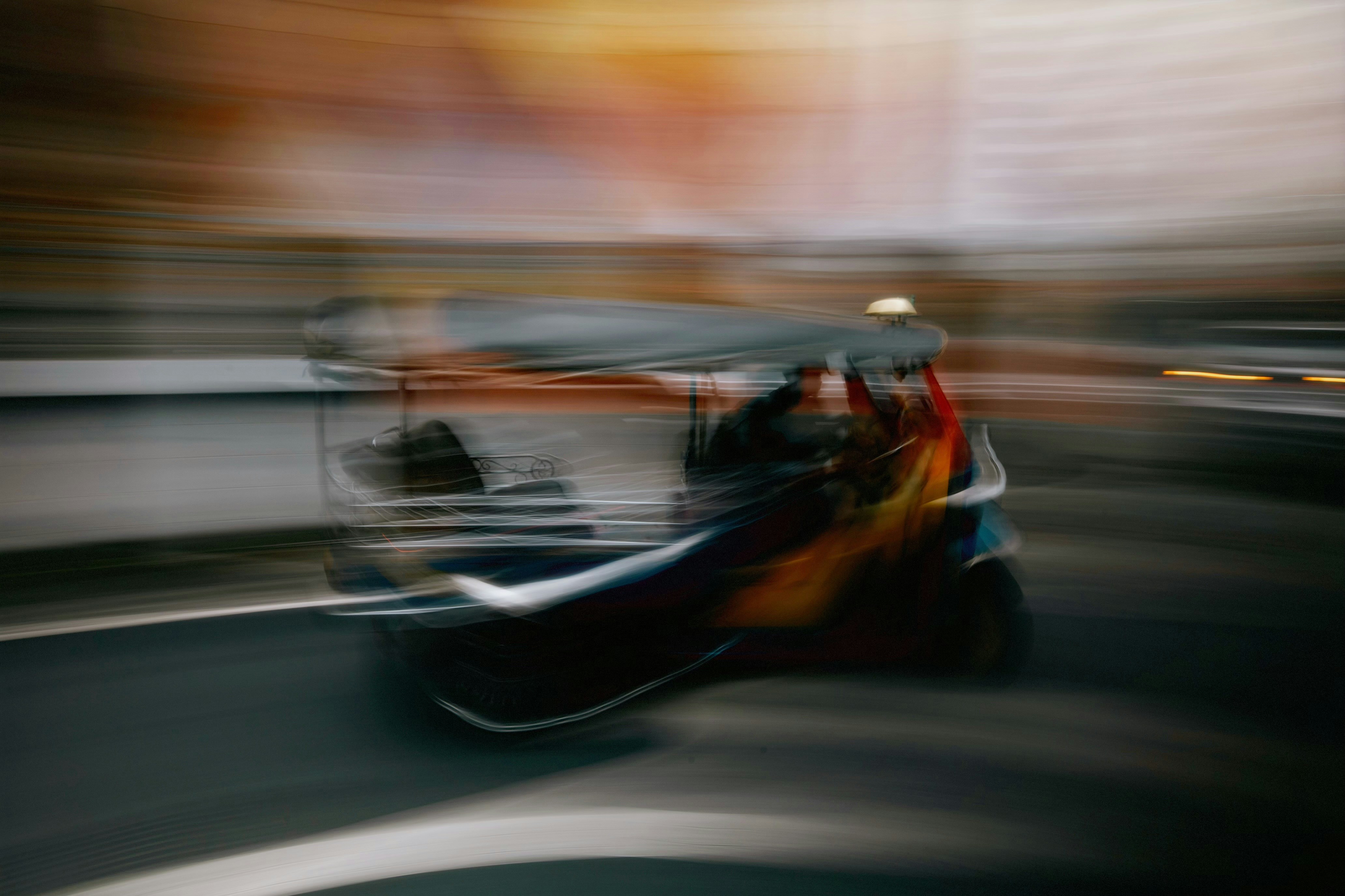 Tuk-tuk speeding through city streets blur
