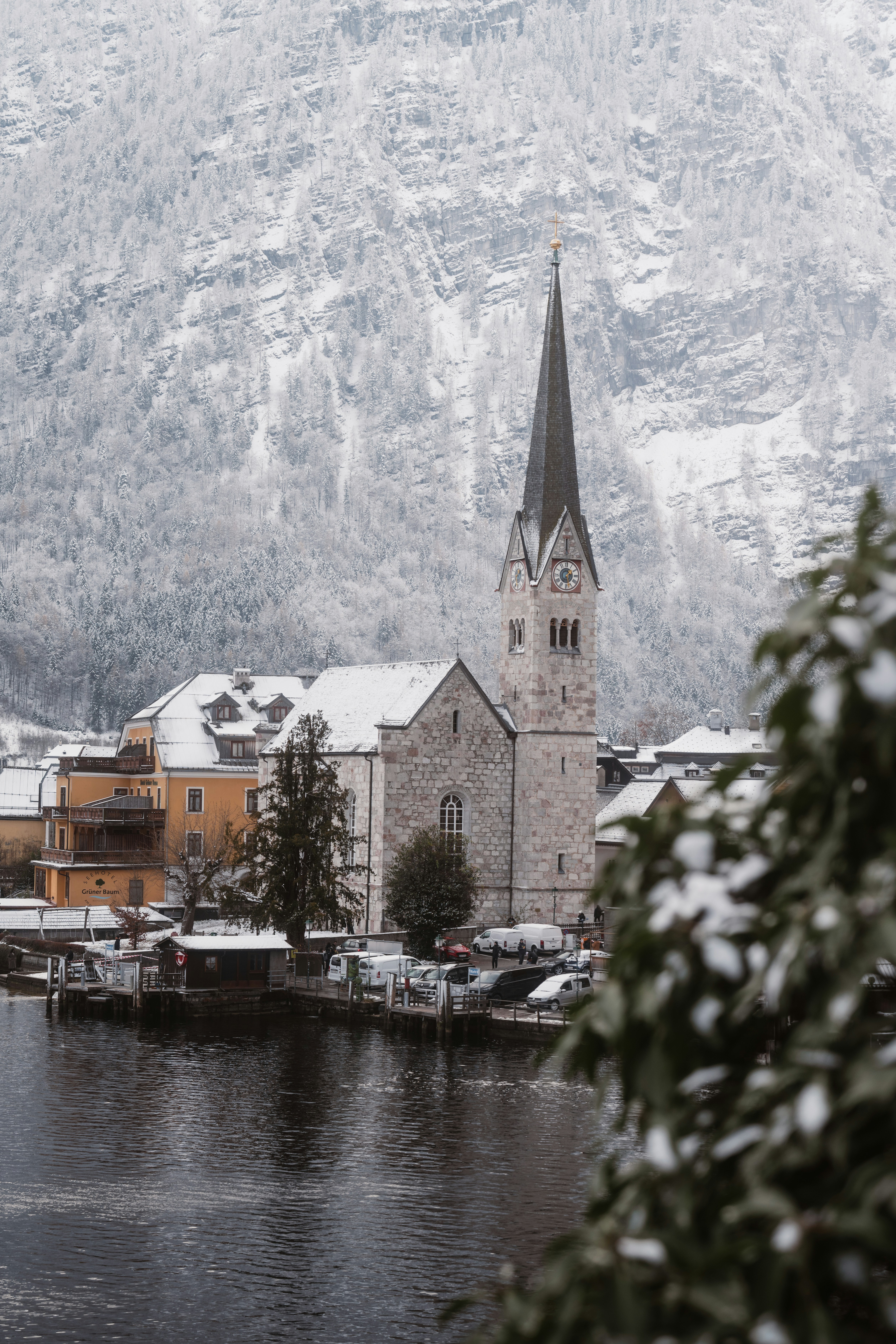 Snow-covered village with a church spire by the water