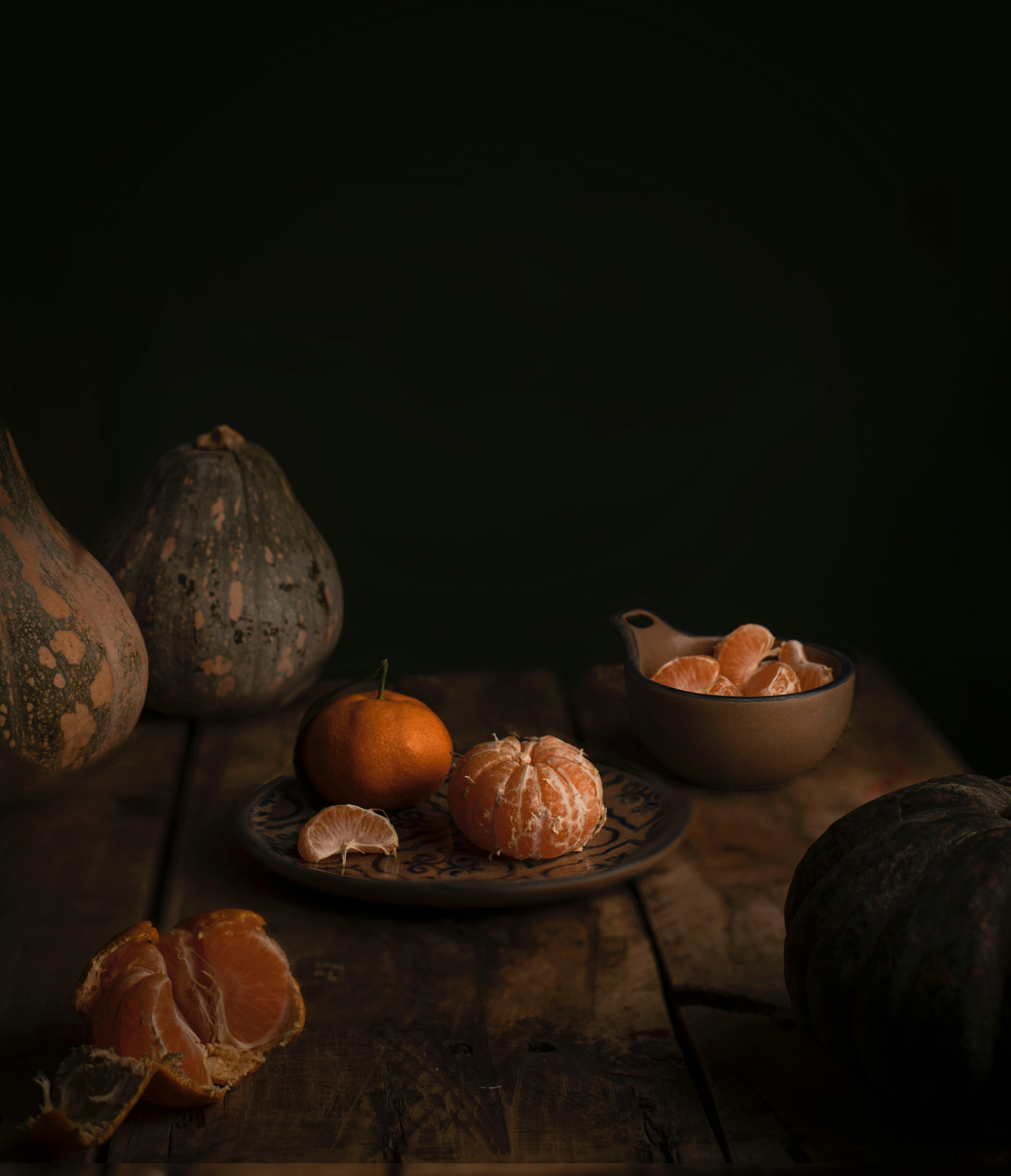 Still life with pumpkins and tangerines on a wooden table
