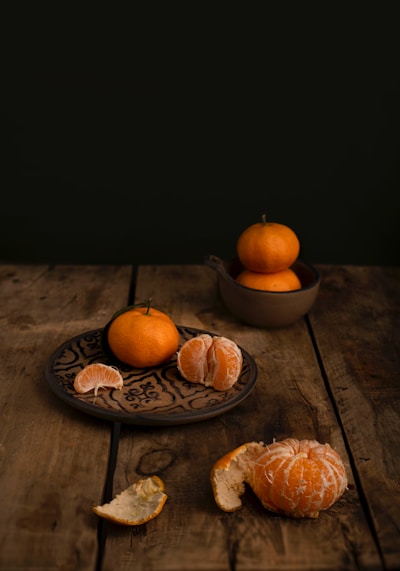 Tangerines arranged on a rustic wooden table.