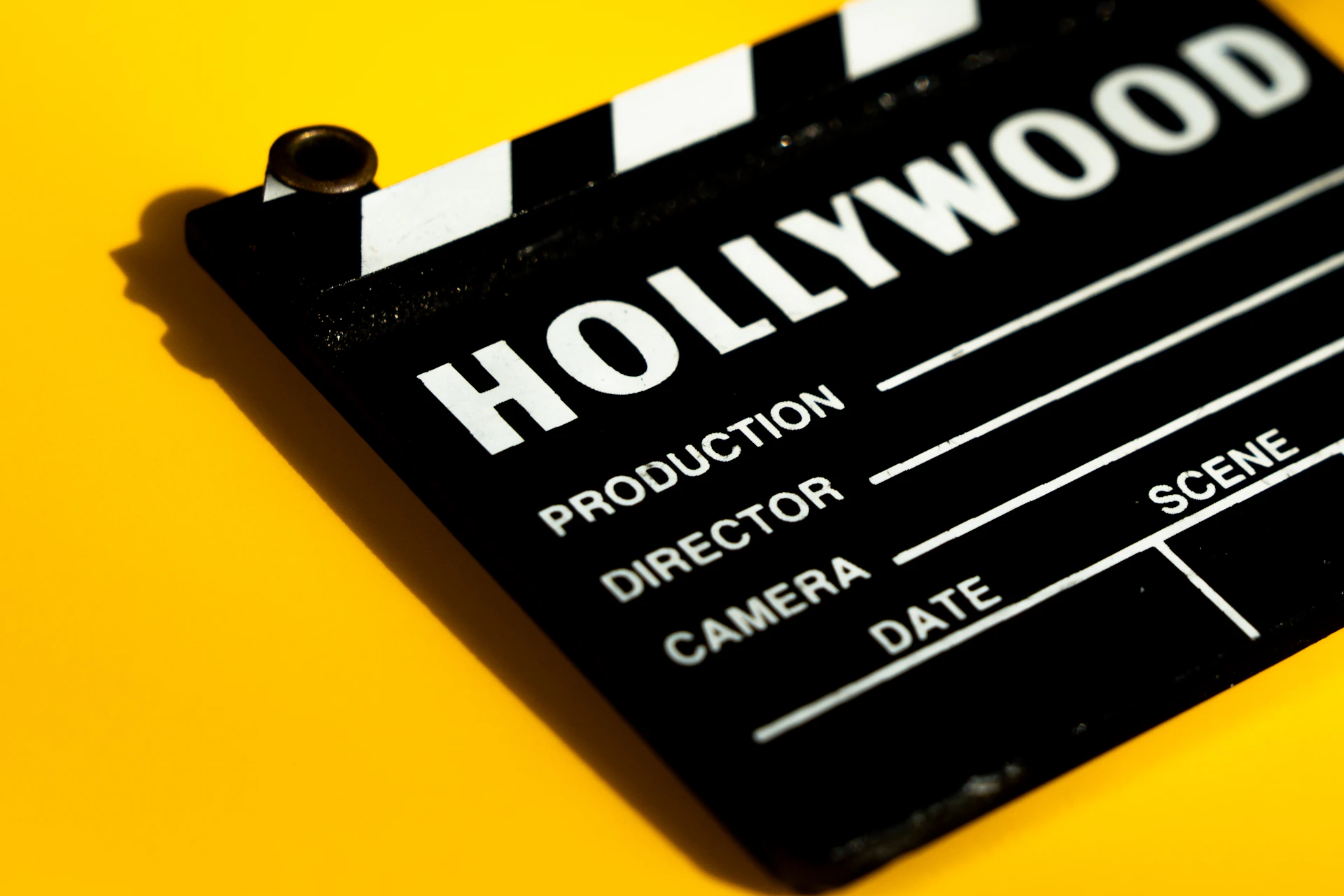 A hollywood clapperboard on a yellow background