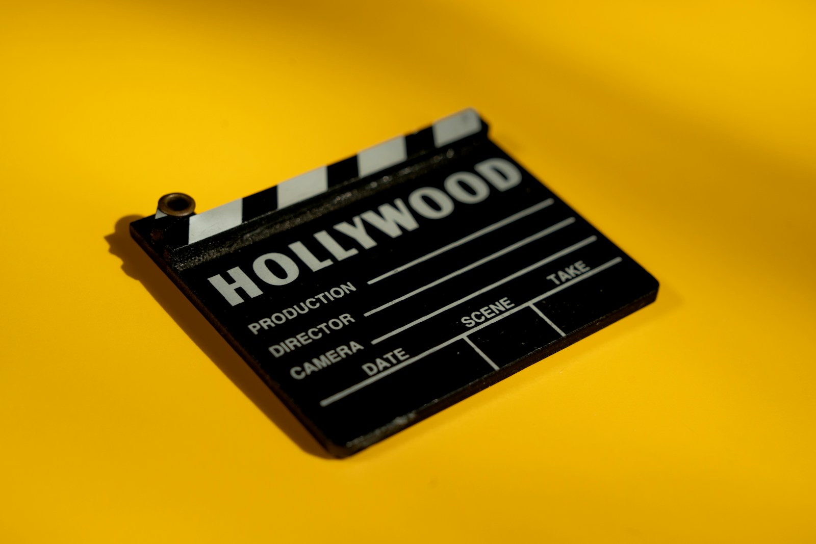 A professional movie clapperboard on a yellow background, symbolizing the fusion of traditional Hollywood filmmaking with emerging AI video generation technology.