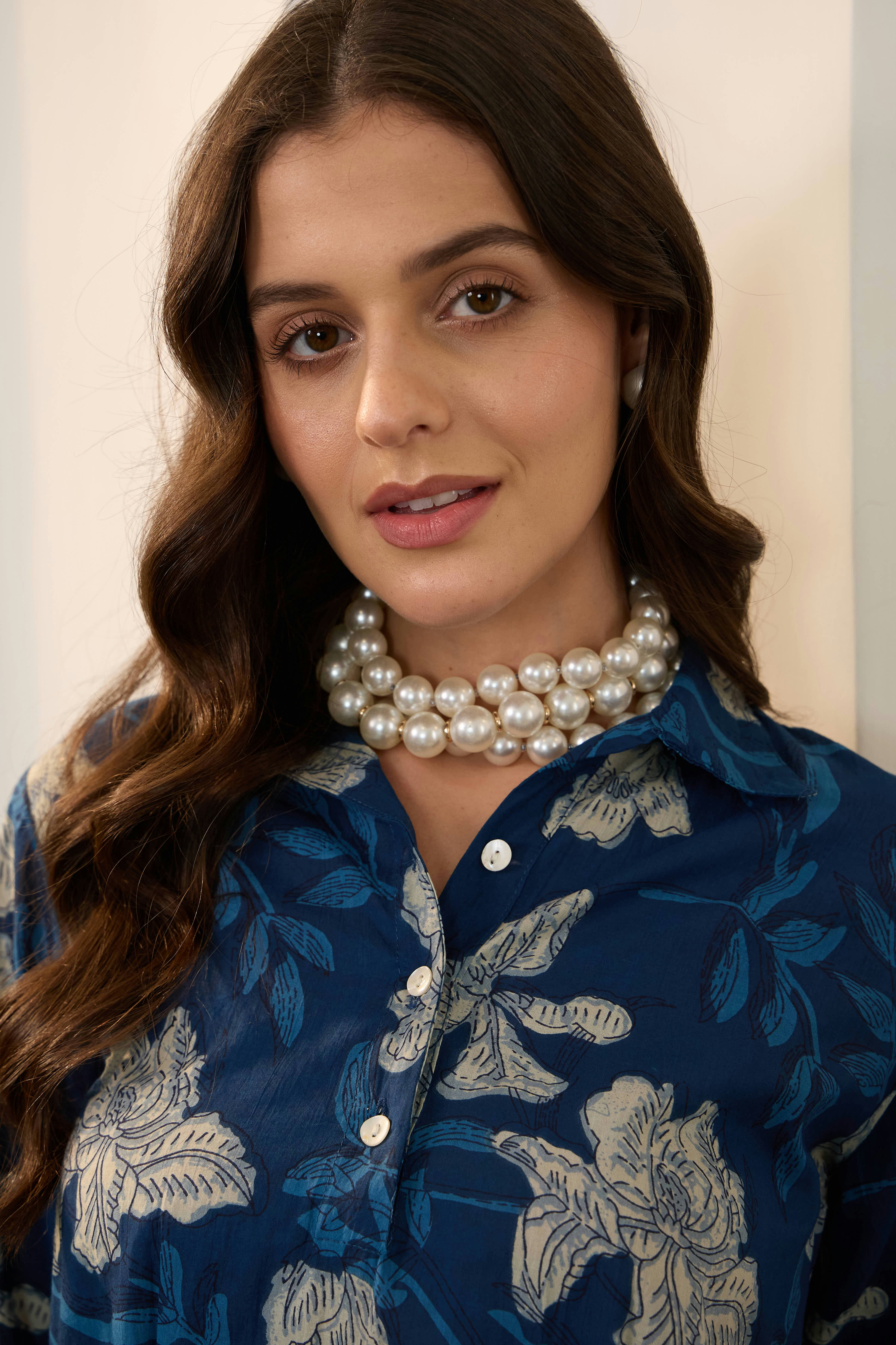 Woman wearing a pearl necklace and floral shirt
