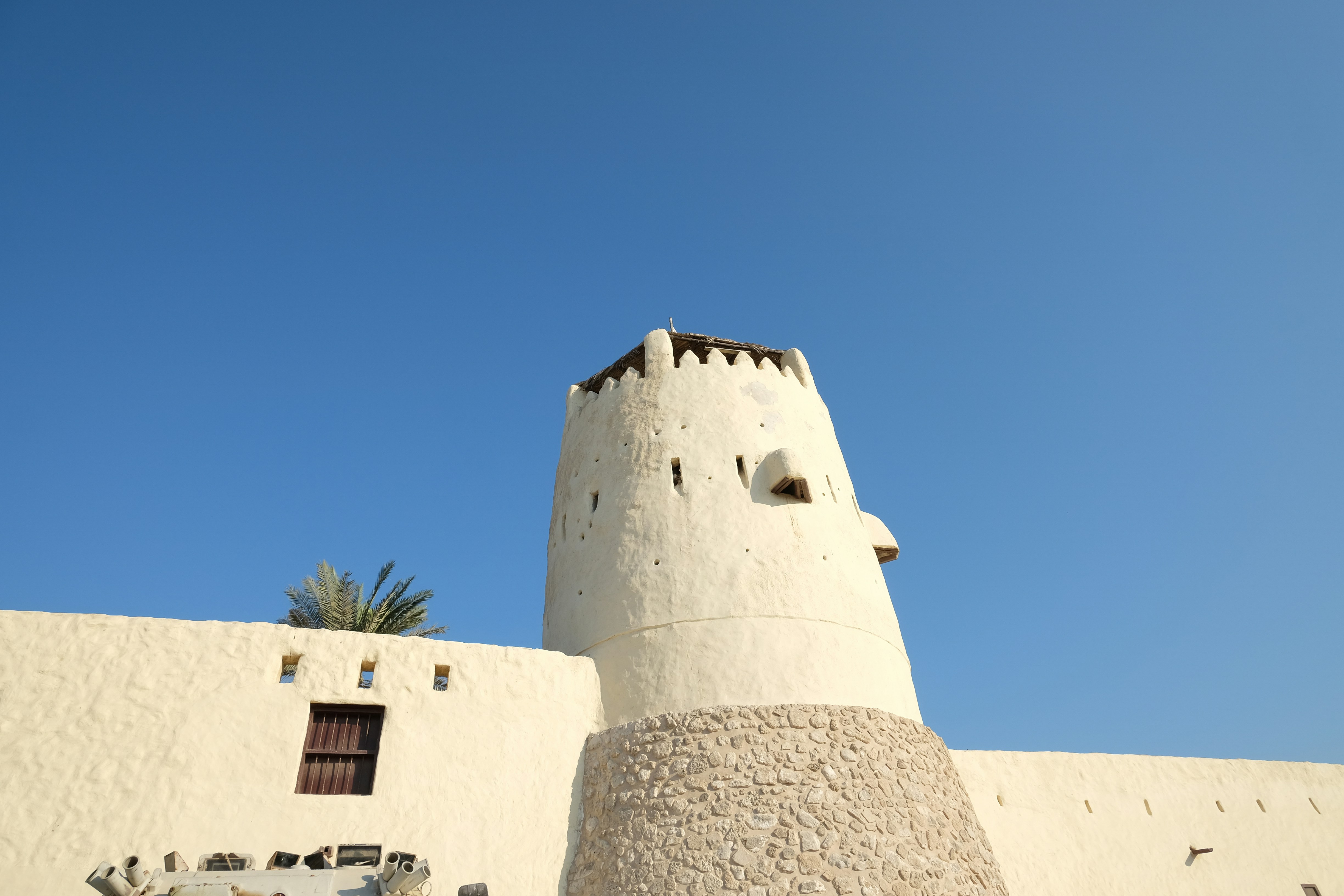 White historic fort tower against a clear blue sky.