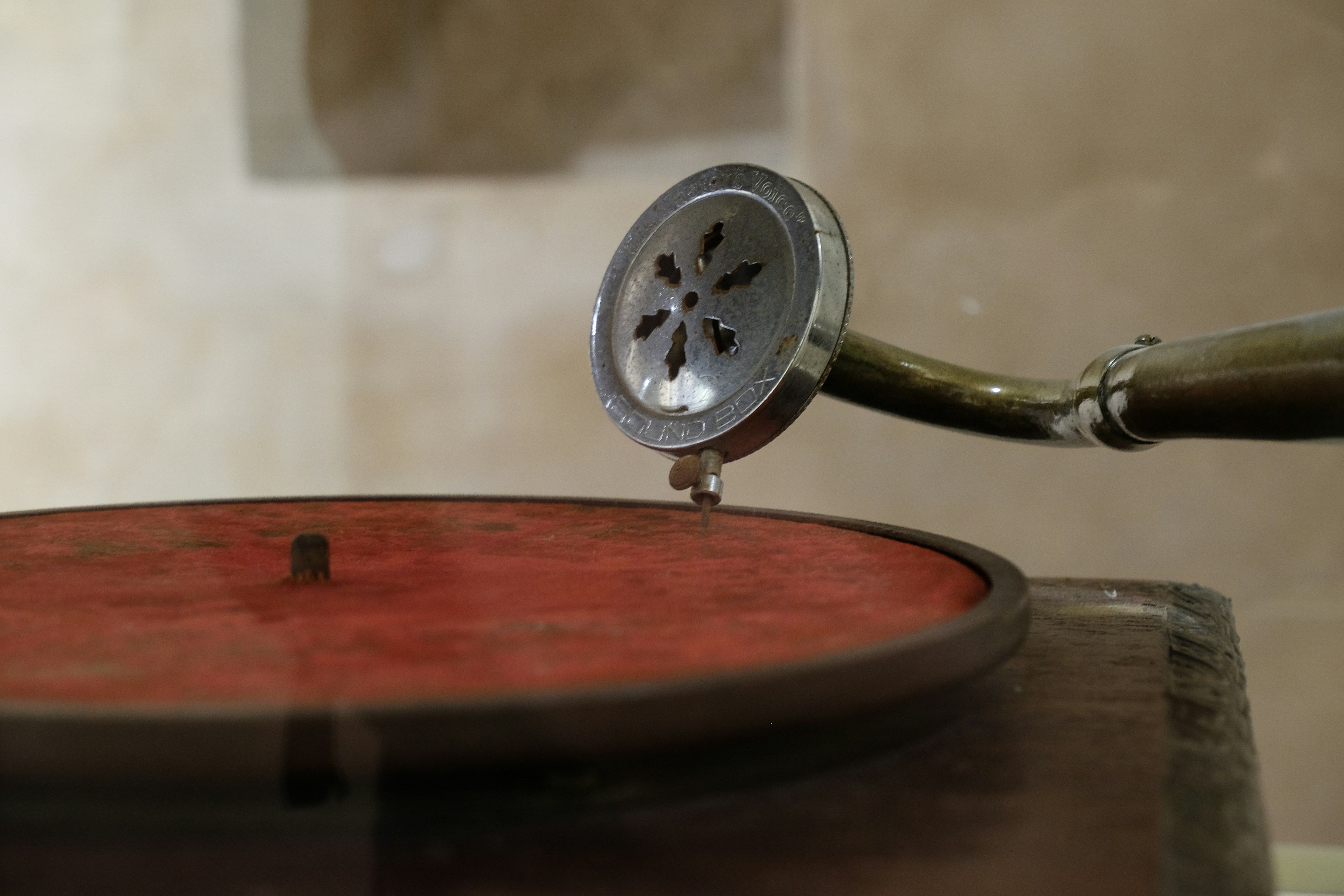 Primer plano de la aguja de un tocadiscos antiguo sobre vinilo rojo.