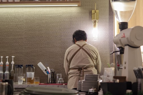 Barista preparing drinks behind a coffee shop counter