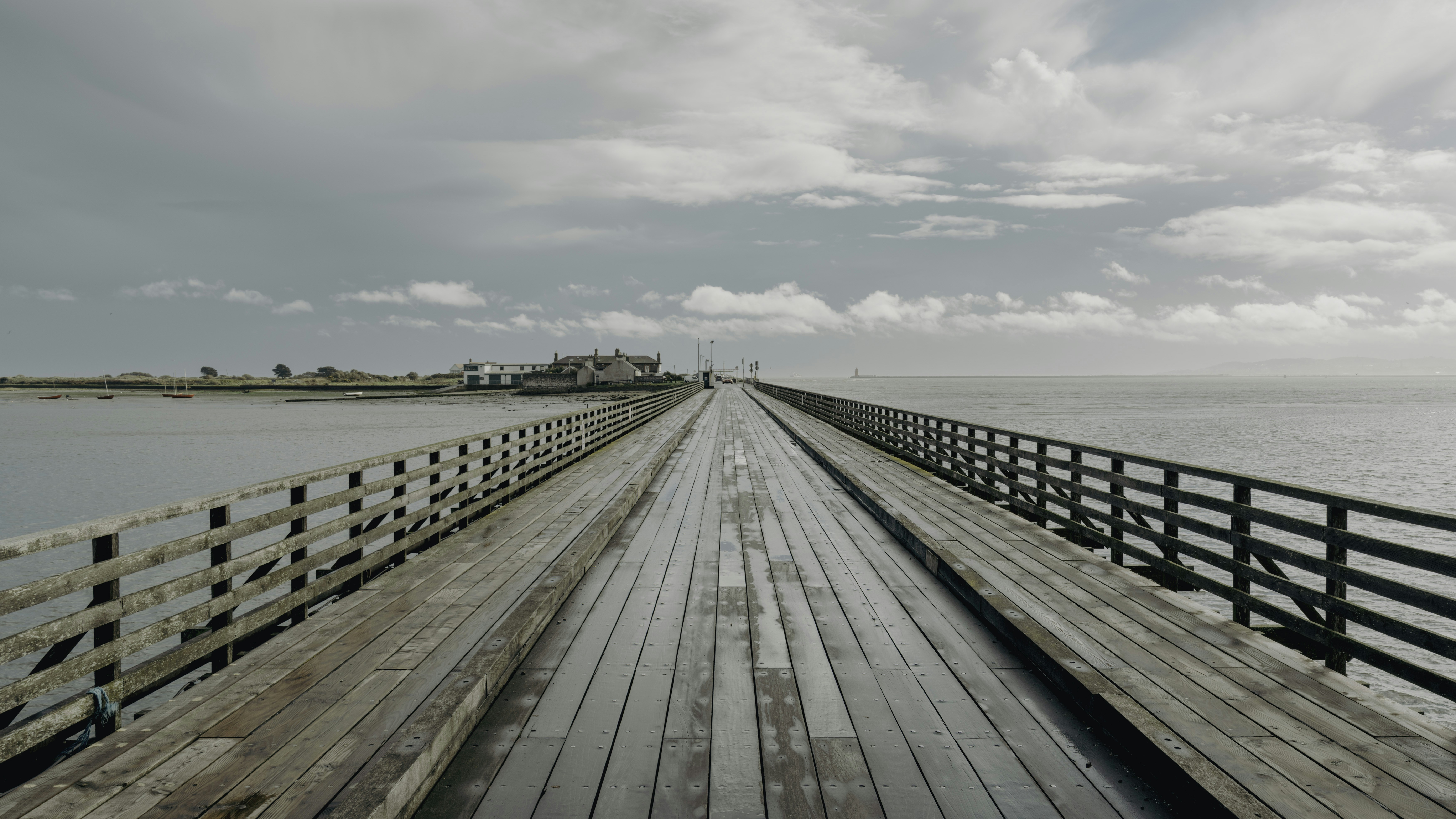 Ein langer Holzpier, der sich über ruhiges Wasser erstreckte
