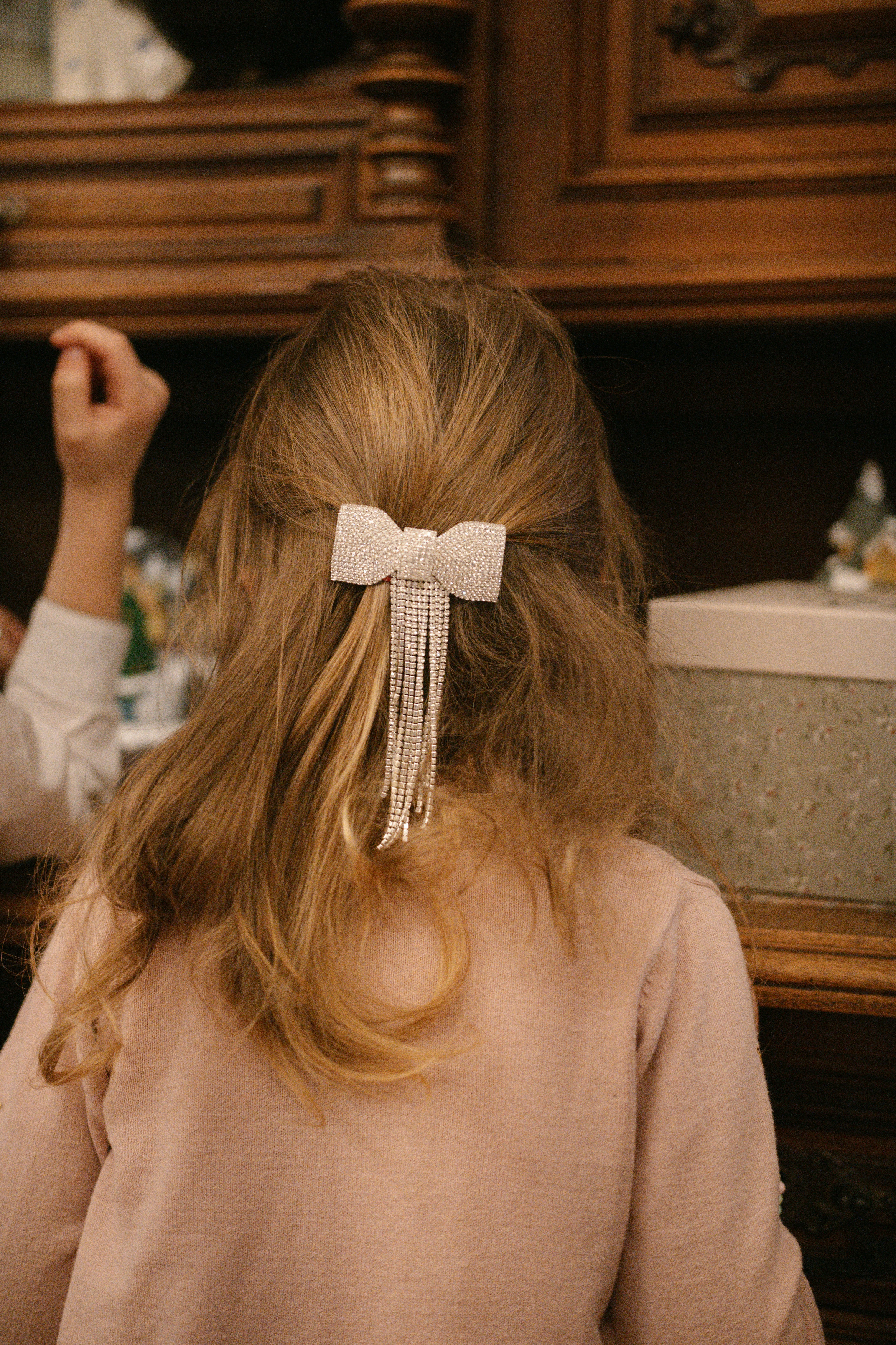Young girl with blonde hair and sparkly bow