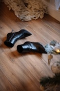 Black leather boots on a wooden floor.